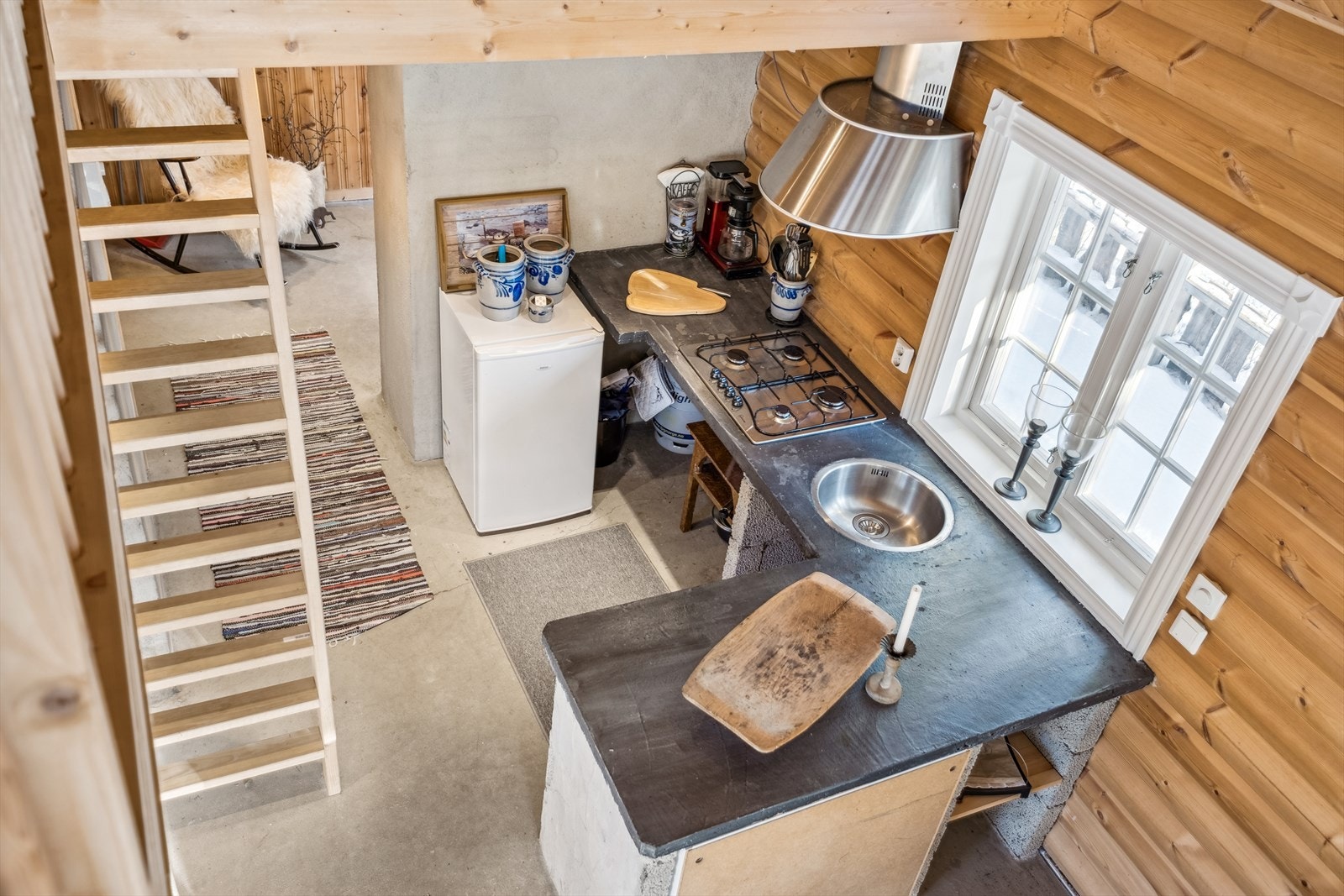 Rustikt kjøkken med et folierte skrog og proflert front. Kjøkkenvanger av letklinkerblokker og benkeplate av støpt betong Galleribilde