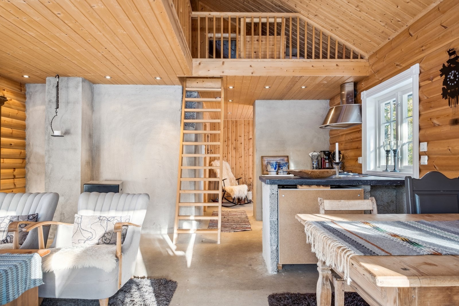 Man kommer inn i et romslig allrom med trapp opp til hems som strekker seg stort sett over hele hytta. Galleribilde