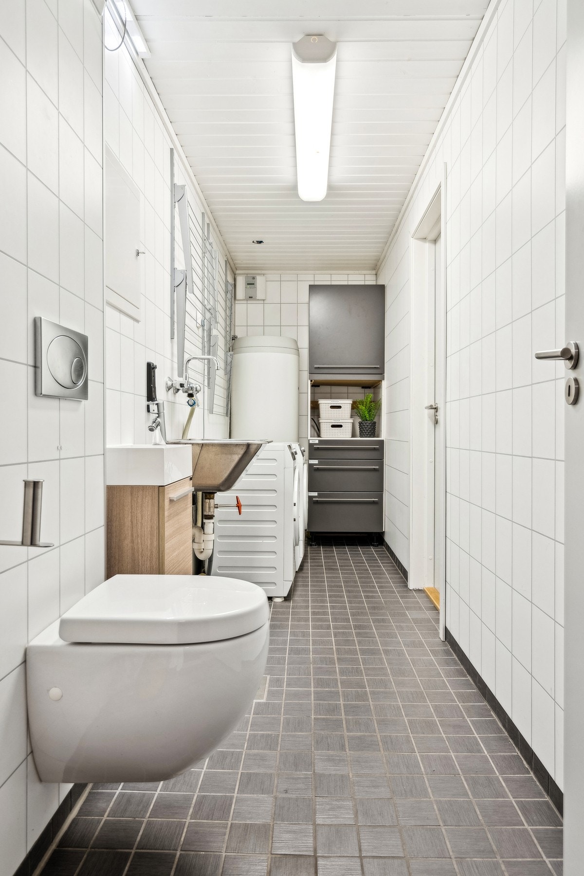 Praktisk vaskerom med Wc. Dør til høyre på vaskerom leder til en bod. Galleribilde