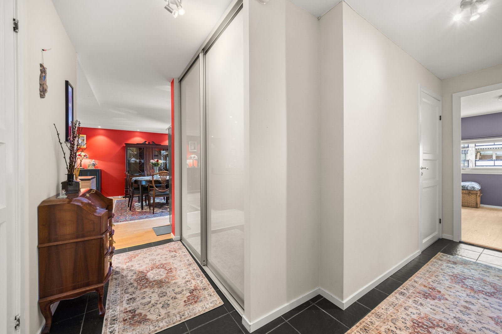 Velkommen inn til en romslig entré med praktisk skyvedørsgarderobe Galleribilde