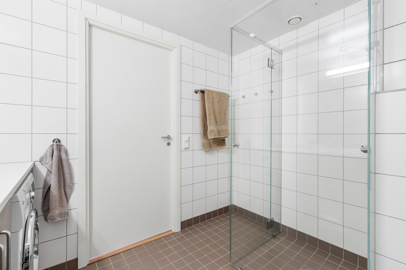 Dusj på gulv i hjørnet. Dusjbatteri tilkoblet veggmontert hånddusj. Dusjvegger av glass. Opplegg for vaskemaskin. Galleribilde