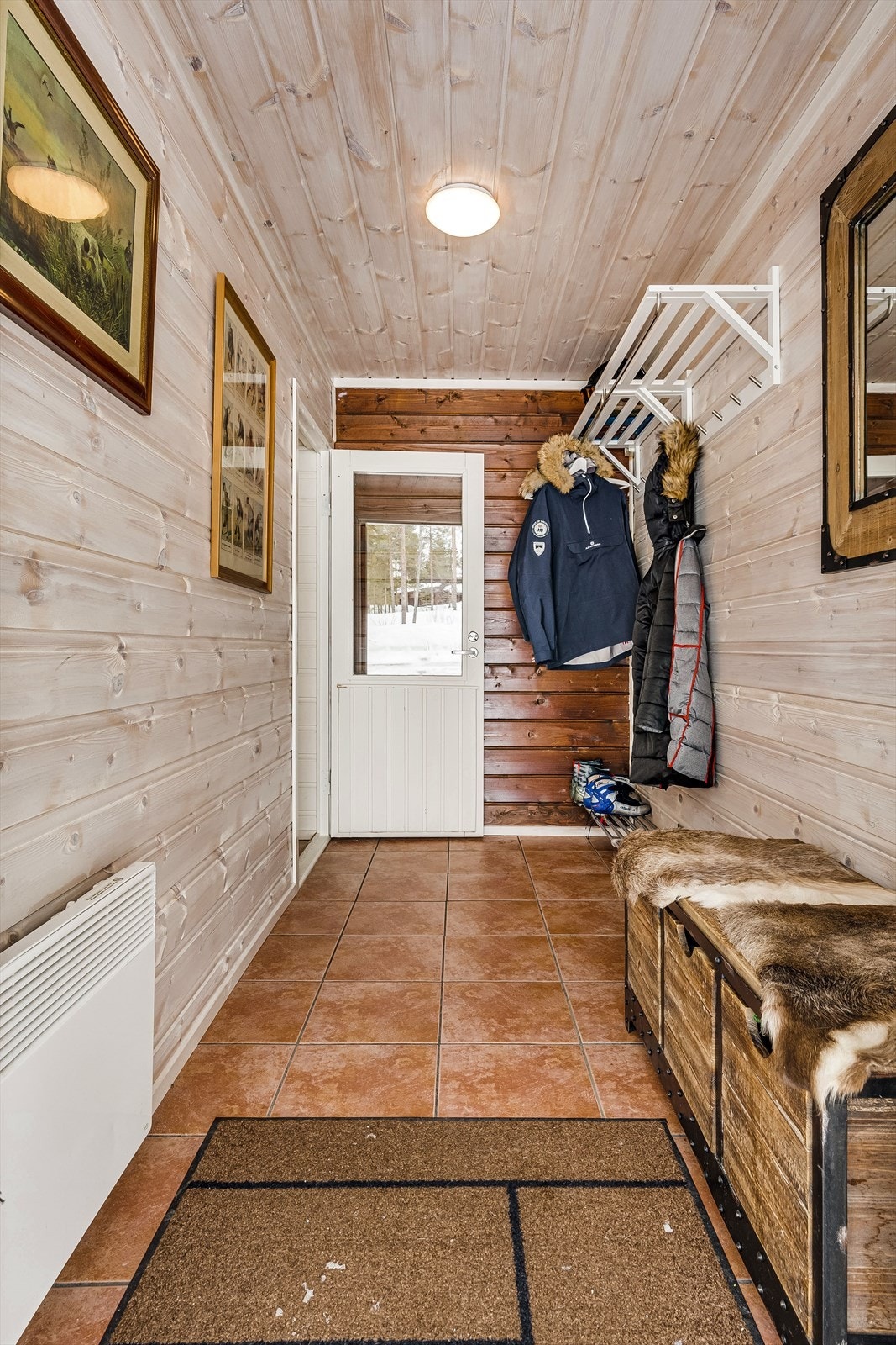 Gangen i hytta har god omkledningsplass og rom for garderobeløsninger. Her er det lysbeiset panel på vegger og i tak, samt varmekabler under gulvfliser. Galleribilde