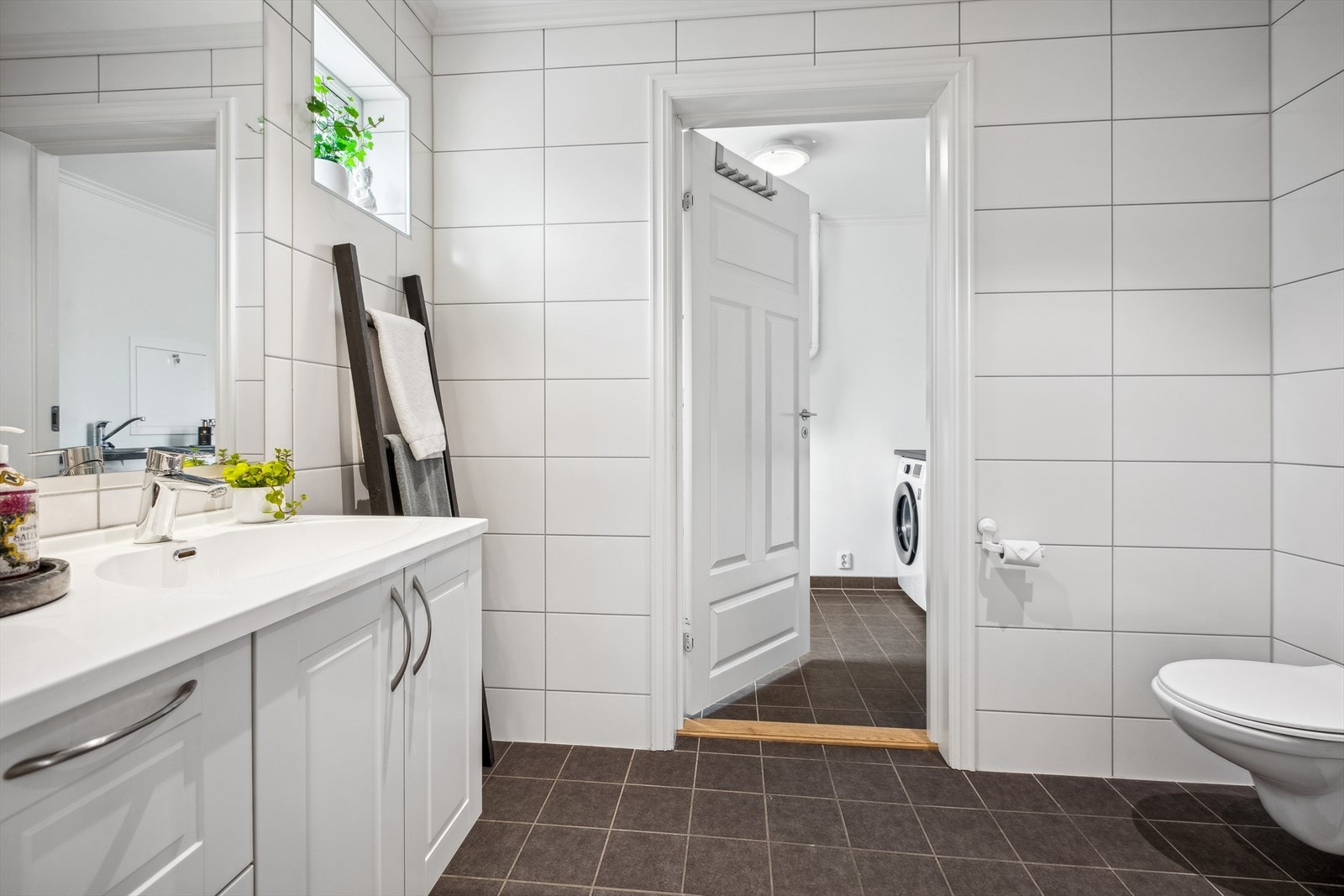 Tett tilknyttet entreen er det både et romslig baderom samt et vaskerom. Vaskerommet har egen inngangsdør fra gårdsplassen - perfekt for barnefamilien! Galleribilde