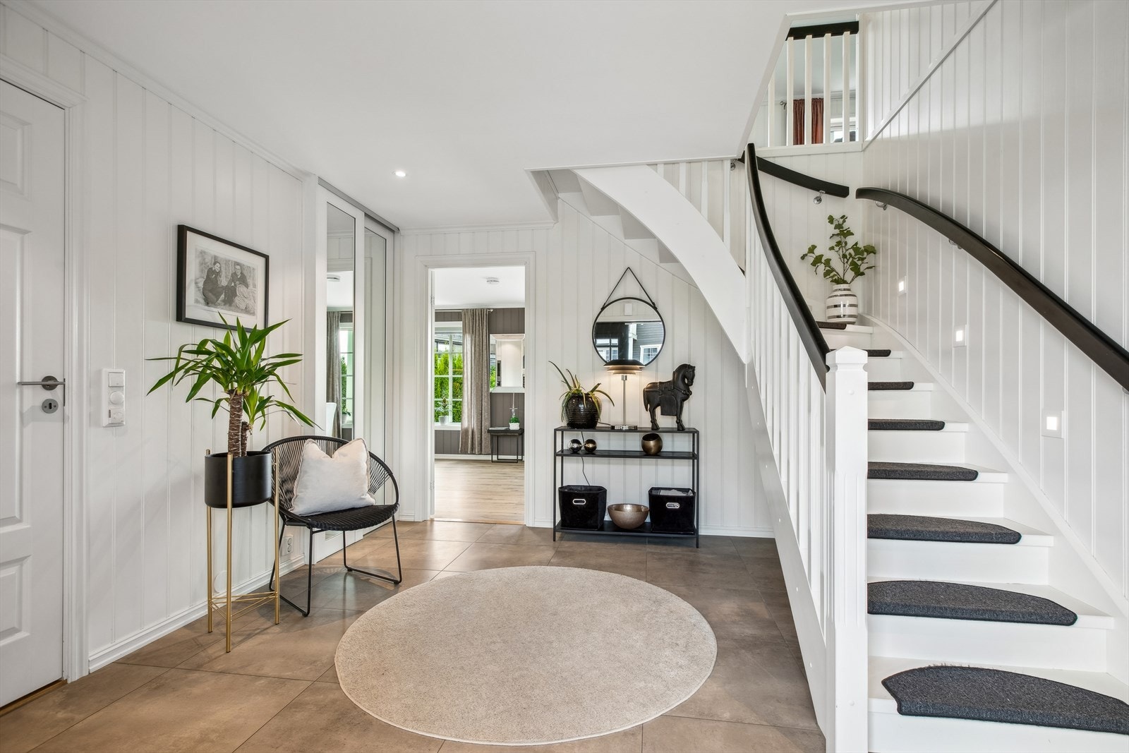 Fra en 2-fløyet ytterdør inntrer du en meget innbydende og romslig entré med store fliser på gulv. Her er det også lagt varmekabler. Entreen har et garderobeskap med speilfronter samt et kontor og bod for ekstra oppbevaring. Galleribilde