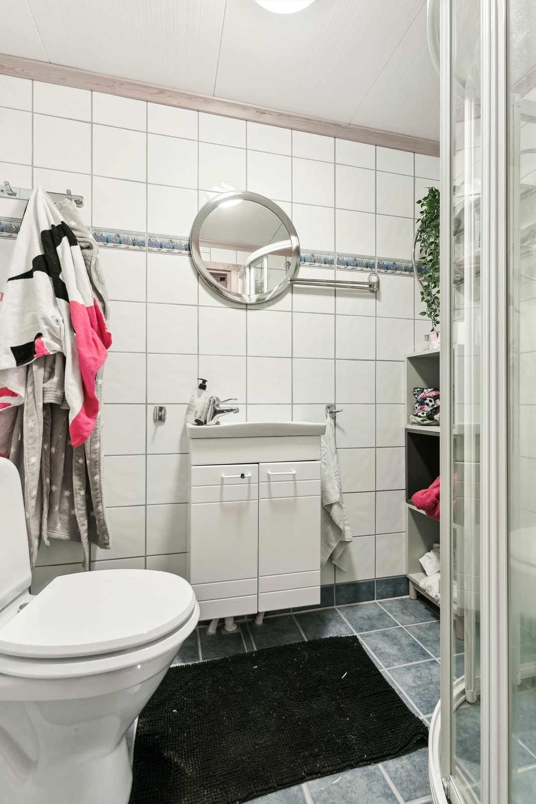Badet er utstyrt med dusj på vegg med sokkellist, wc, servant og varmekablar i golv. Galleribilde