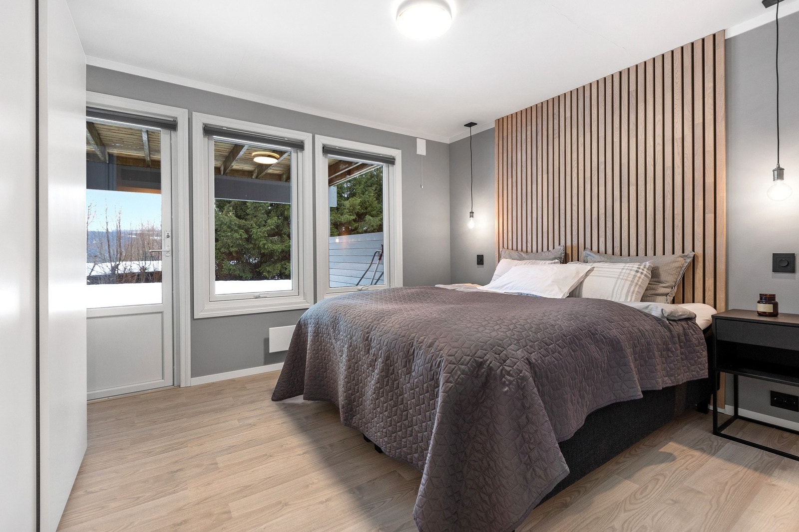 Stort og pent hovedsoverom med utgang til terrasseplatting og hageareal. Galleribilde