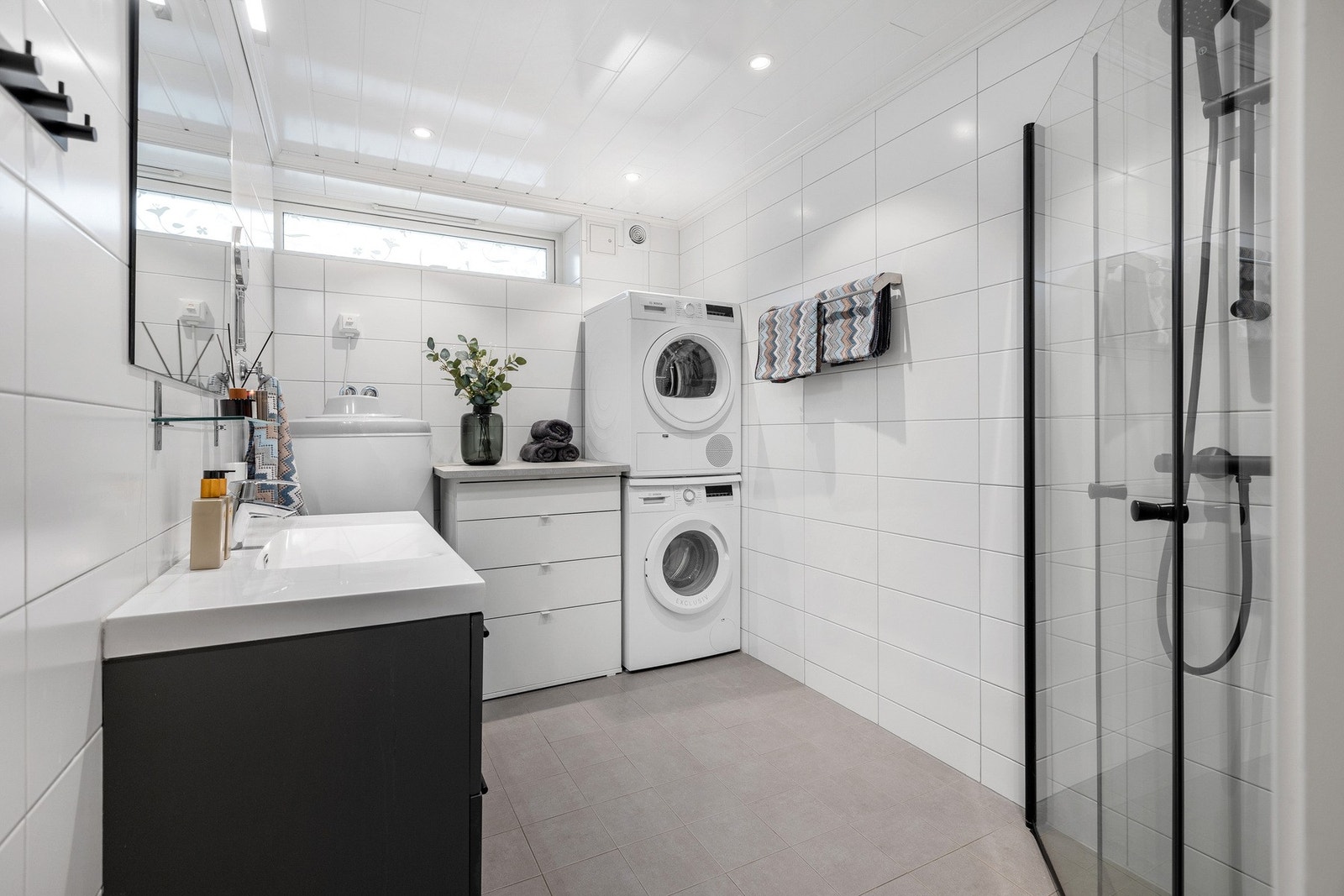 Romlig bad/vaskerom i boligens underetasje. Badet ble oppusset i 2017 med bl.a. flislagt på gulv og vegger med varmekabler. Galleribilde