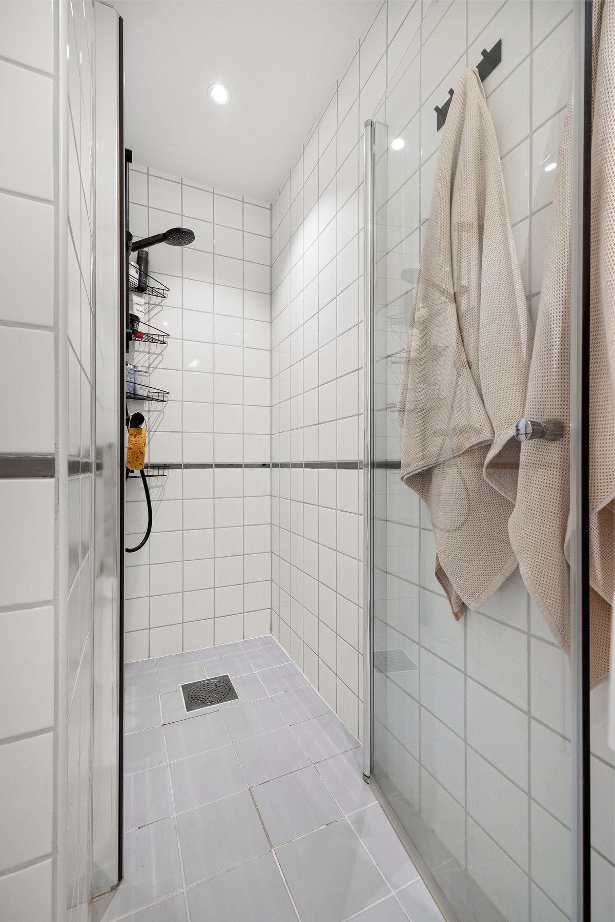 Dusjnisje på bad. Det er mål tilstrekkelig fall på badegulvet og tilstrekkelig høydeforskjell mellom topp sluk og fliser. Galleribilde