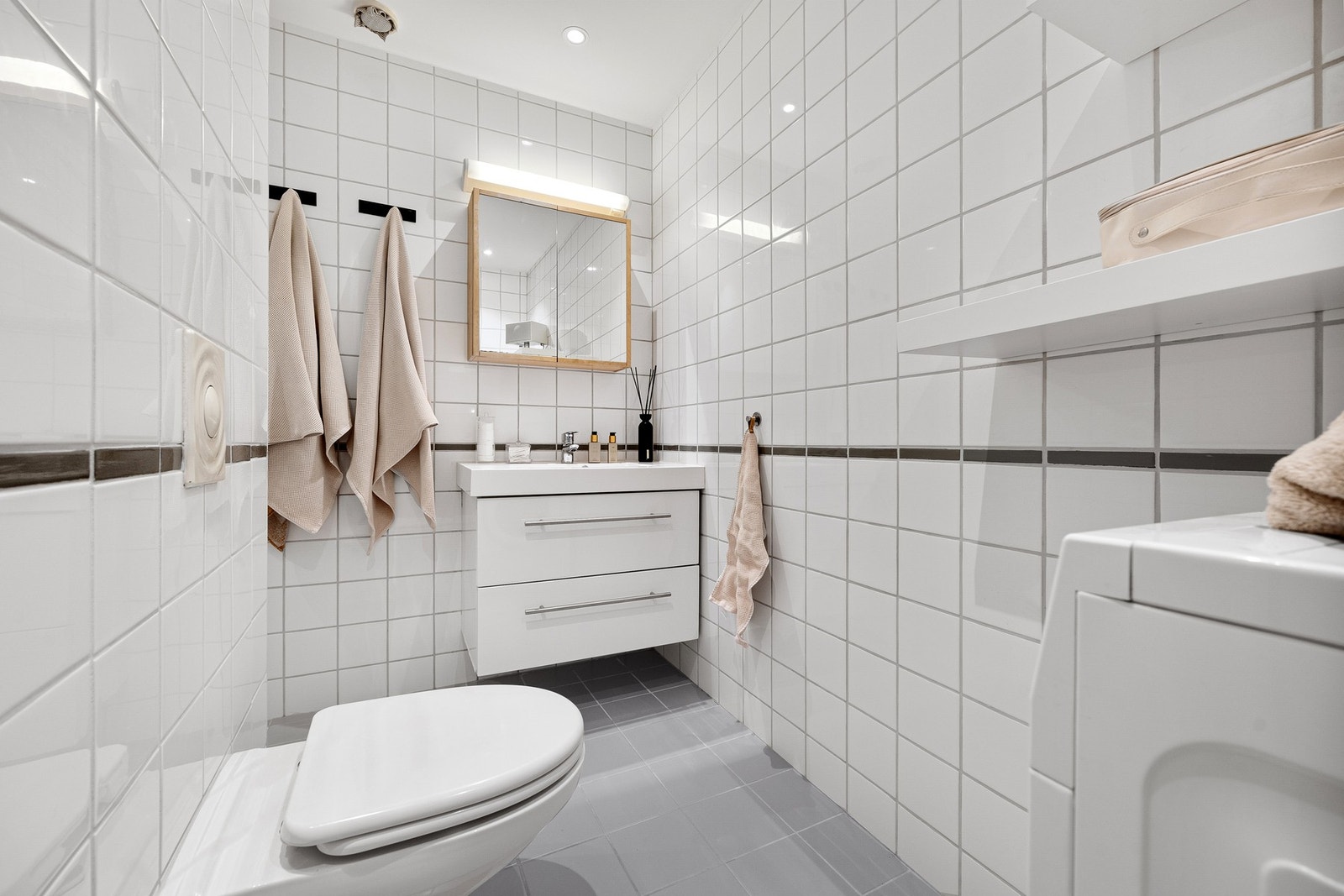 Flislagt bad med varmekabler i gulv og opplegg for vaskemaskin. Galleribilde