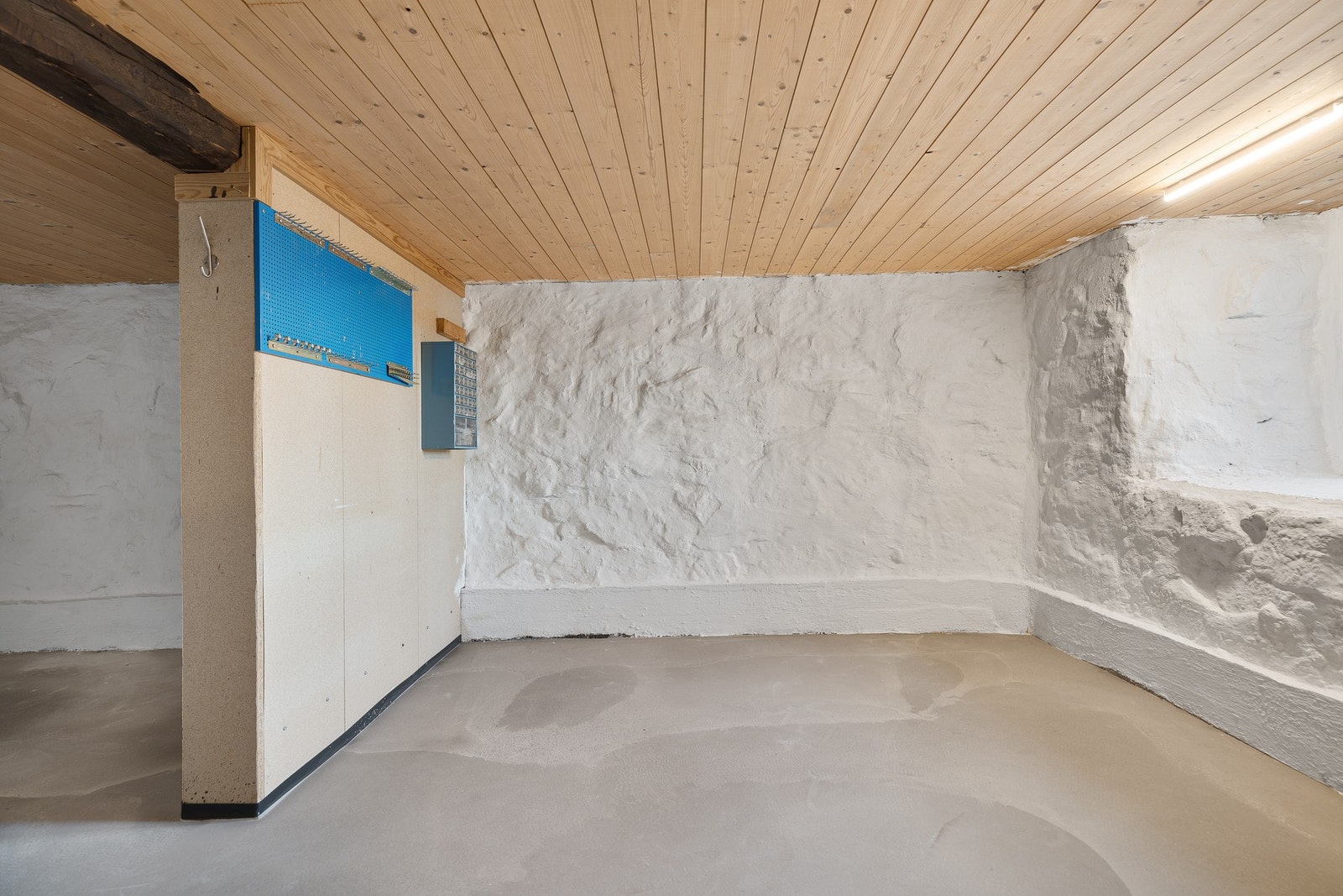 Gulvet i kjelleren er støpt og veggene er malt med kalkmaling. Dette rommet har tidligere vært potetkjeller men brukes i dag som snekkerbod. Galleribilde