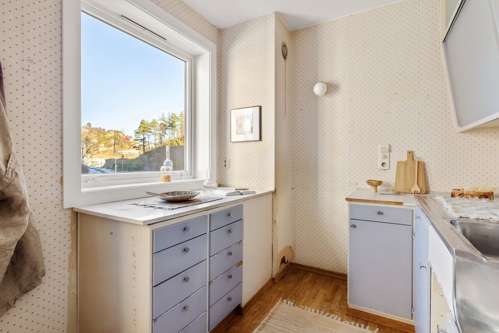 Kjøkkeninnredningen har slette fronter, laminat og stål benkeplate med nedfelt vask i stål. Galleribilde