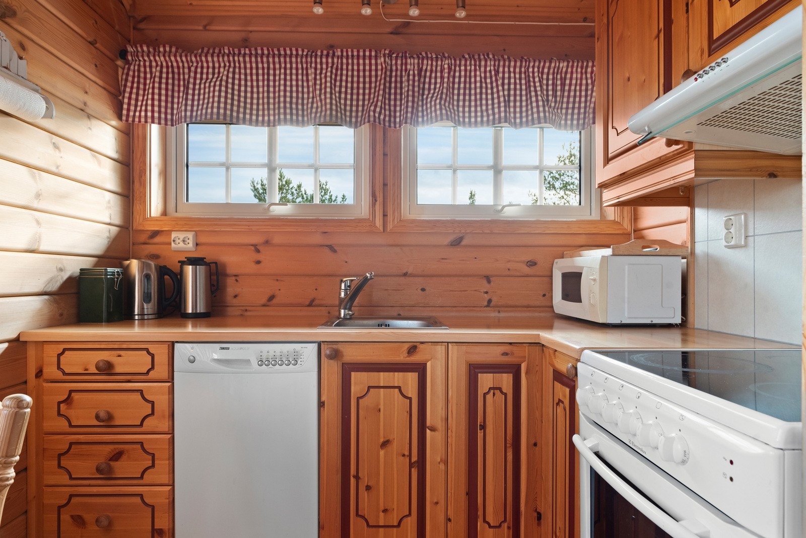 Kjøkkeninnredning med folierte skrog og glatte fronter. Benkeplate med vask. Avsatt plass og opplegg for vaskemaskin, komfyr og et kjøleskap (disse medfølger) Galleribilde