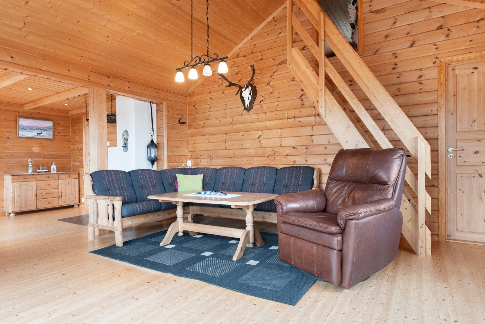 Sofaseksjonen ligger på fløyen til venstre etter inngangspartiet, med hovedsoverommet inn døren til høyre i bildet, og videre opp trappen til hems. Galleribilde