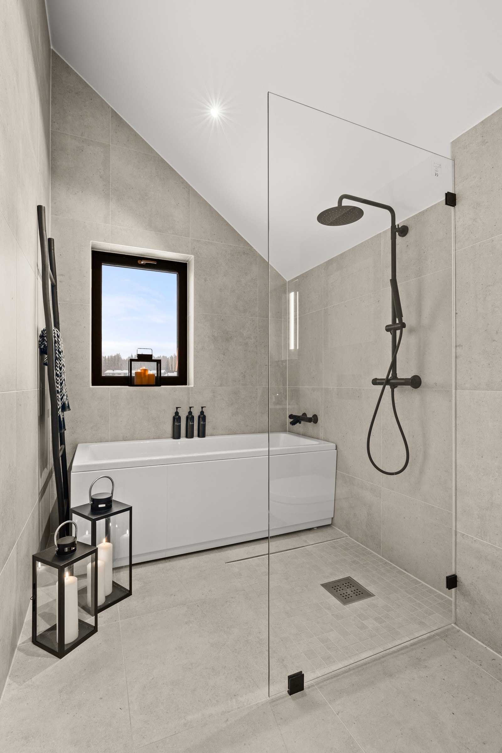 Delikat dusjhjørne med regnfallsdusj, badekar og skilledør i glass. Galleribilde