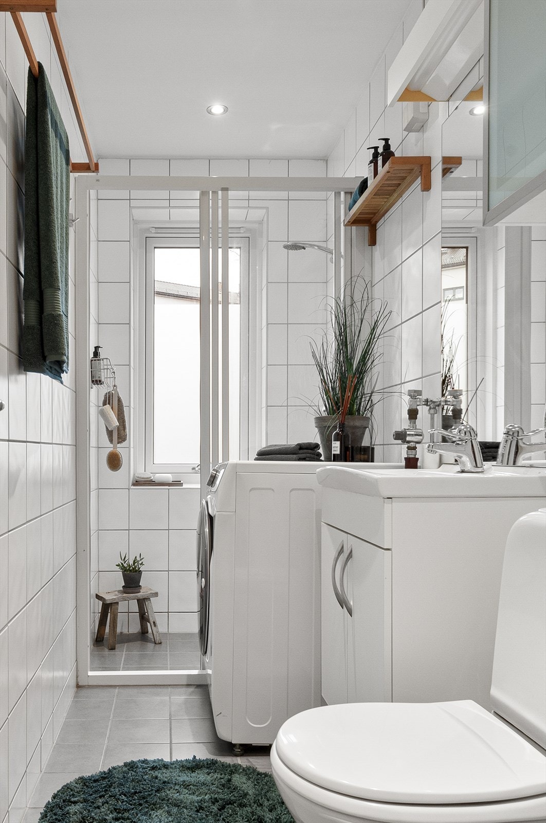 Lyst og pent bad utstyrt med dusjnisje, naturlig avtrekk, opplegg for vaskemaskin, servantskap og wc Galleribilde