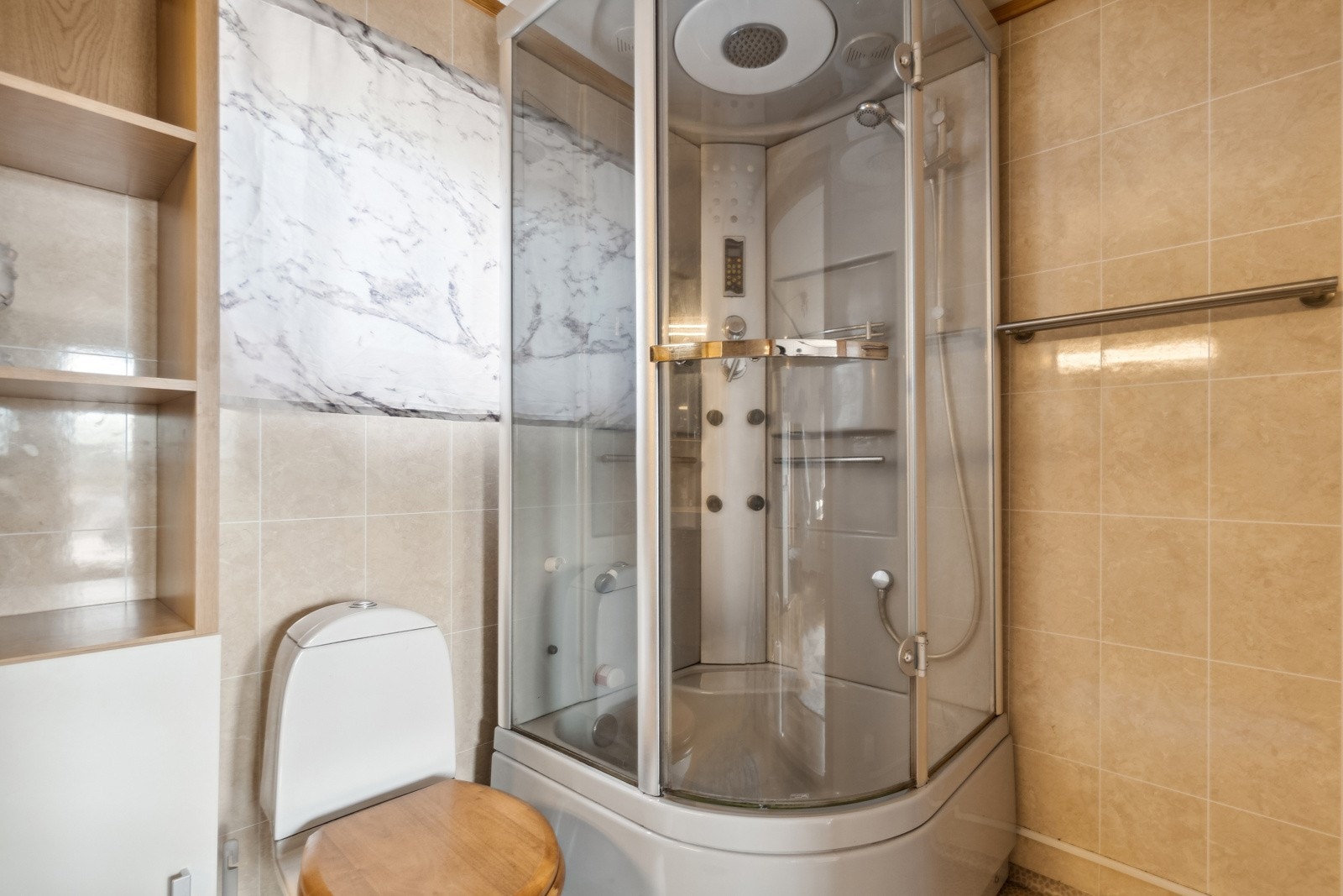 Badet er utstyrt med vegghengt servant, speil, toalett, dusjkabinett og et skap for oppbevaring. Galleribilde