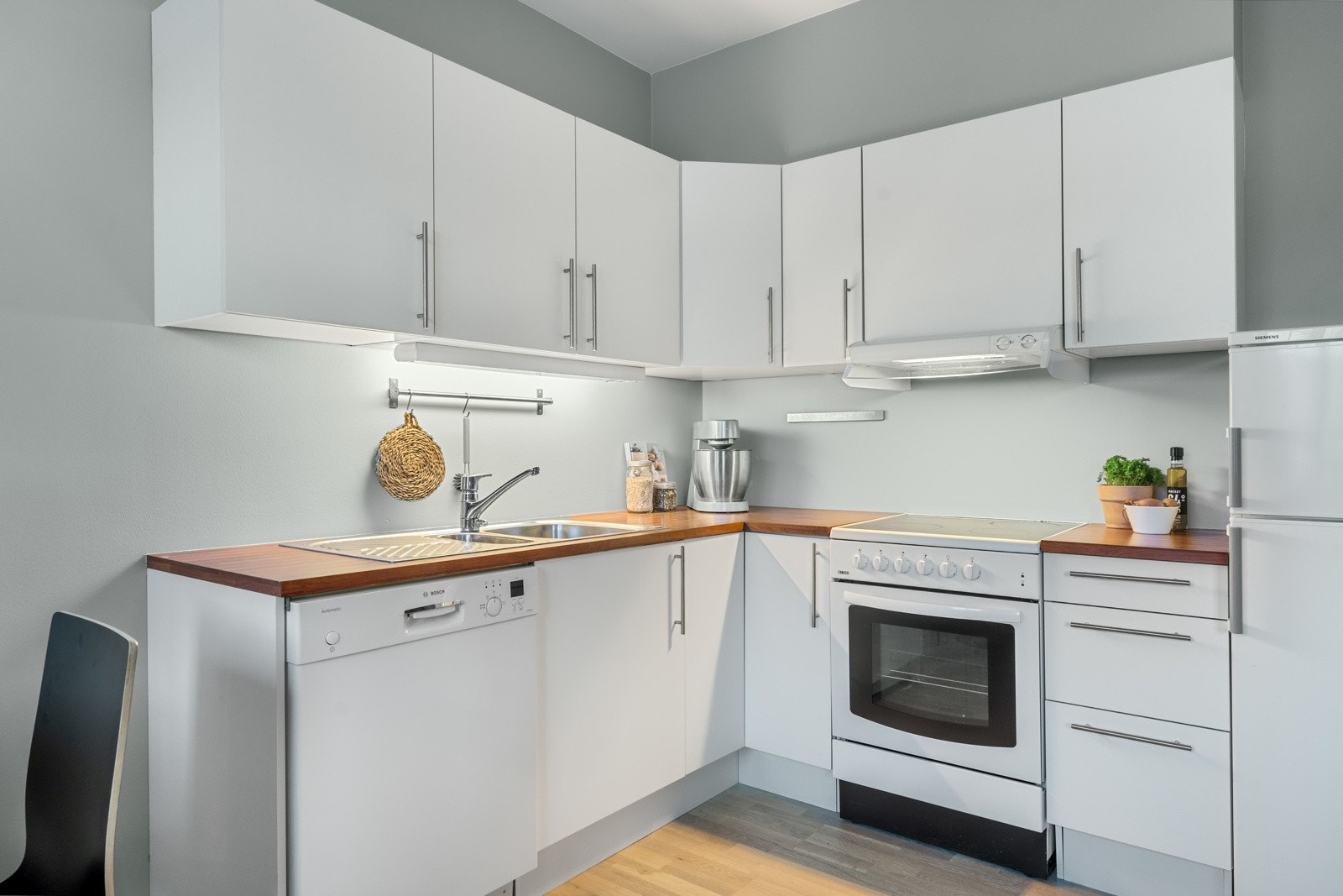 Kjøkkenet har et tidløst design med slette fronter og god oppbevaringsplass i skuffer og skap. Galleribilde