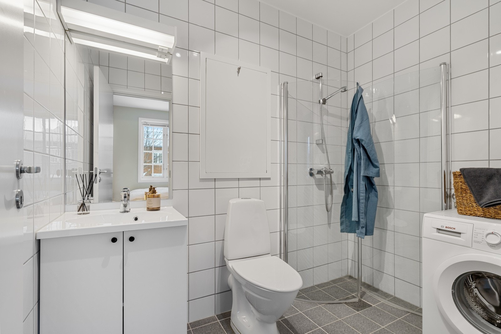 Leilighetens bad har flislagte overflater og elektriske varmekabler i gulvet, noe som gir en lun opplevelse av baderommet. Galleribilde