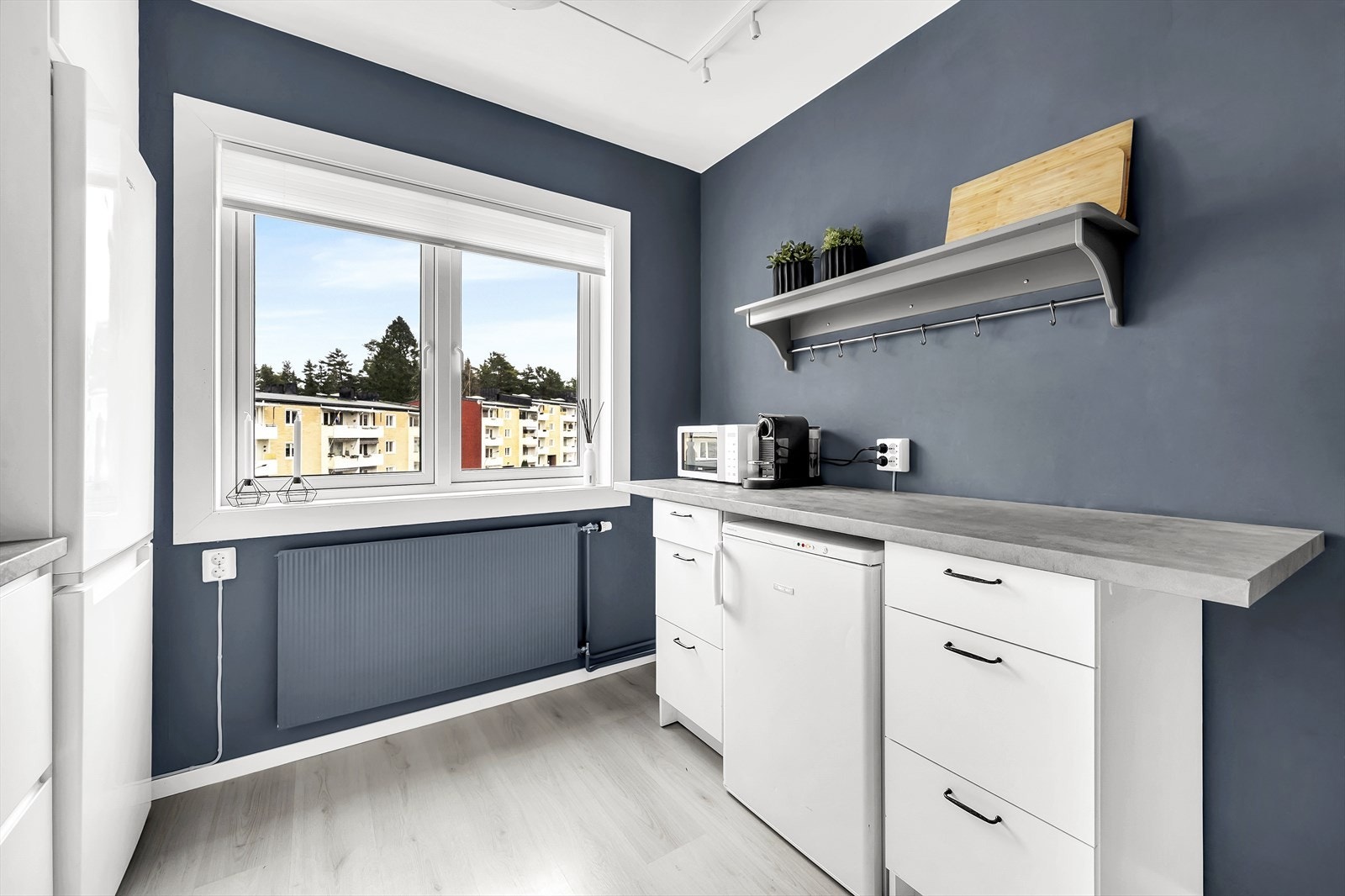 Stilsikker innredning med hvite, glatte fronter og benkeplate i laminat. Galleribilde