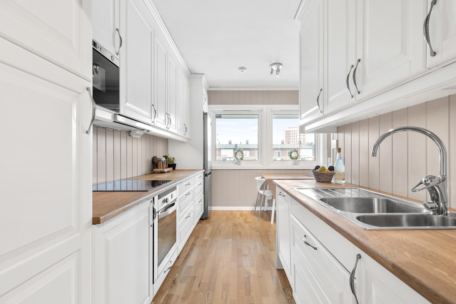 Kjøkkeninnredningen har profilerte fronter fra 2011 og benkeplate av tre med nedfelt oppvaskkum og ettgreps kjøkkenarmatur Galleribilde