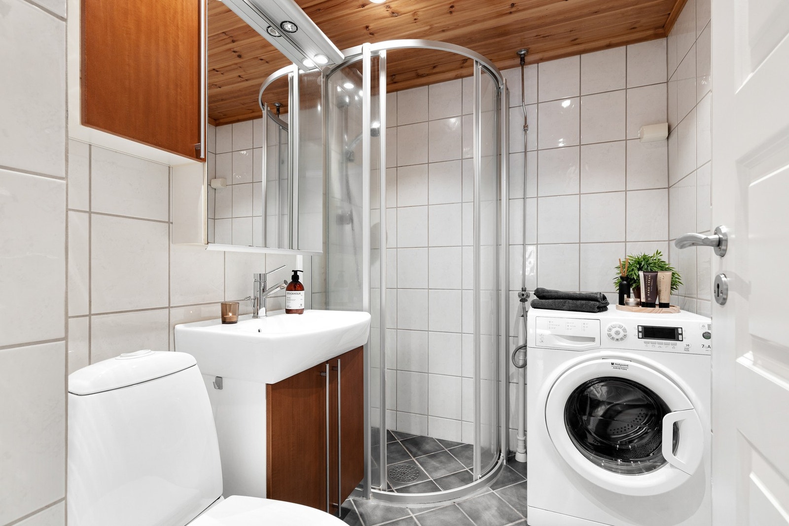 Helfliset bad fra 2005 med gulvvarme. Rommet er innredet med gulvstående toalett, servantinnredning og dusjhjørne Galleribilde