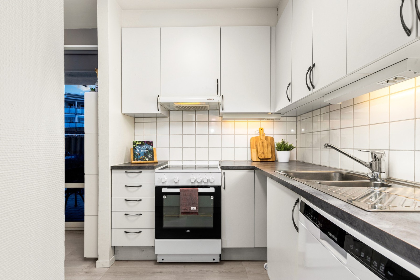 Kjøkken som er delvis skjermet fra stue. Galleribilde