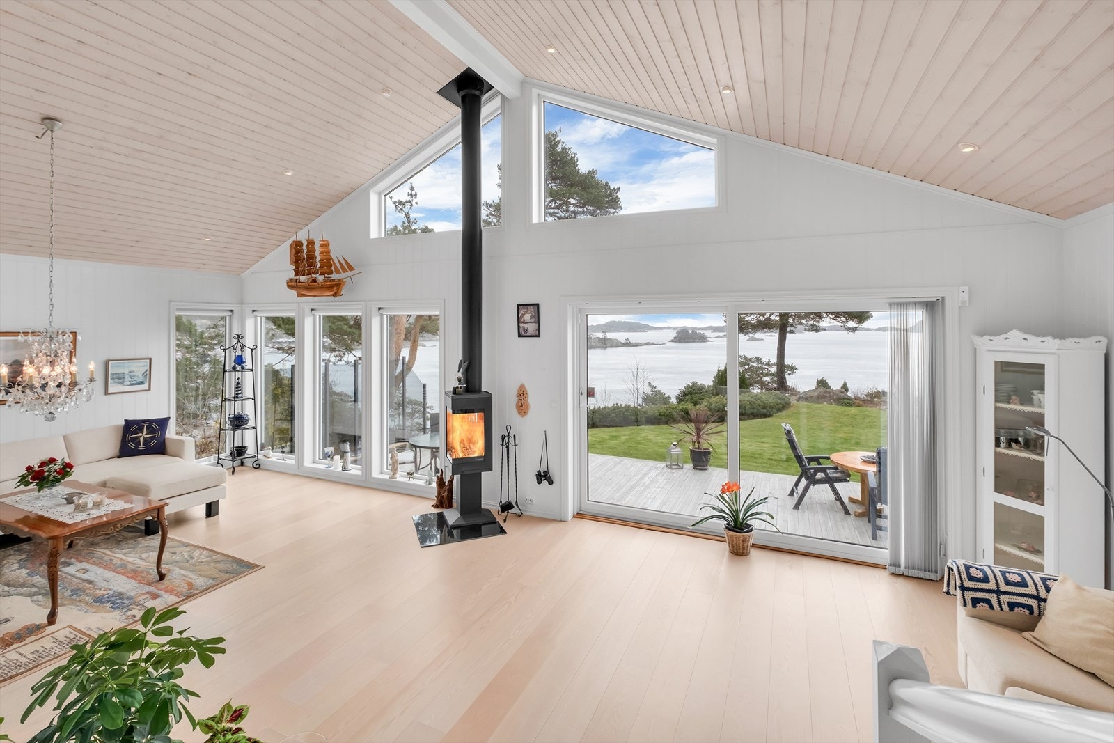 God takhøyde i stue med store vindusflater som gir vakker utsikt og godt med lys inn i rommet Galleribilde