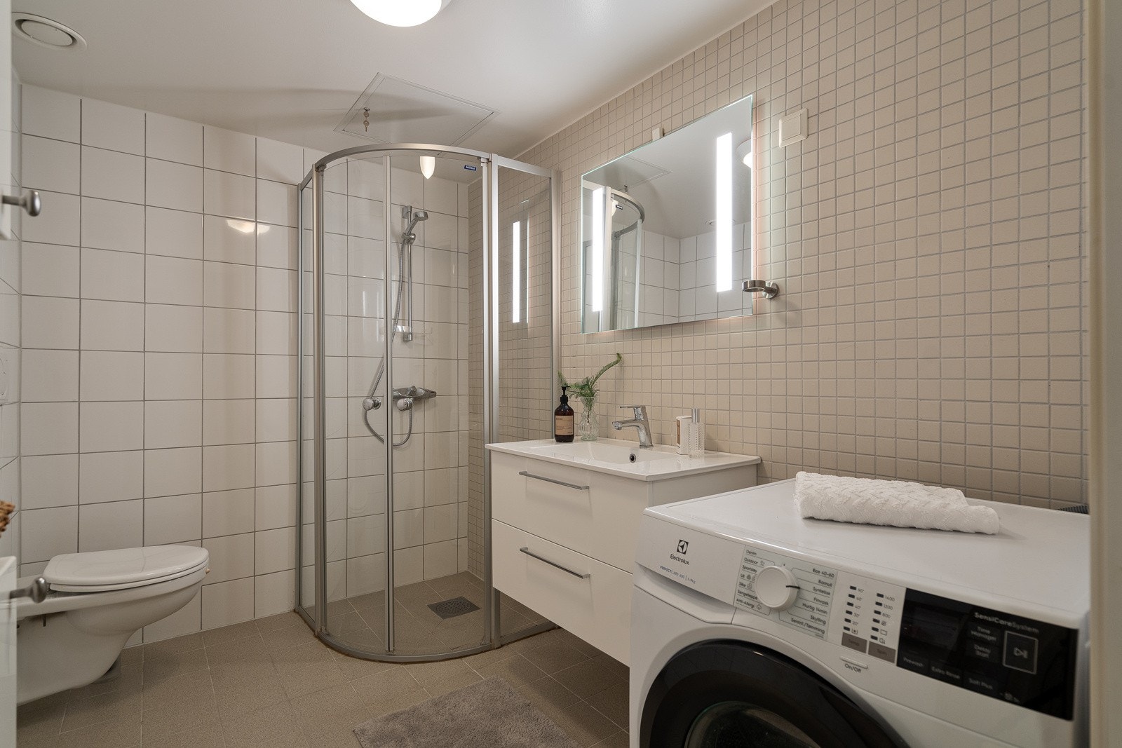 Smakfullt dusjbad med stilrene fliser på gulv og vegger Galleribilde