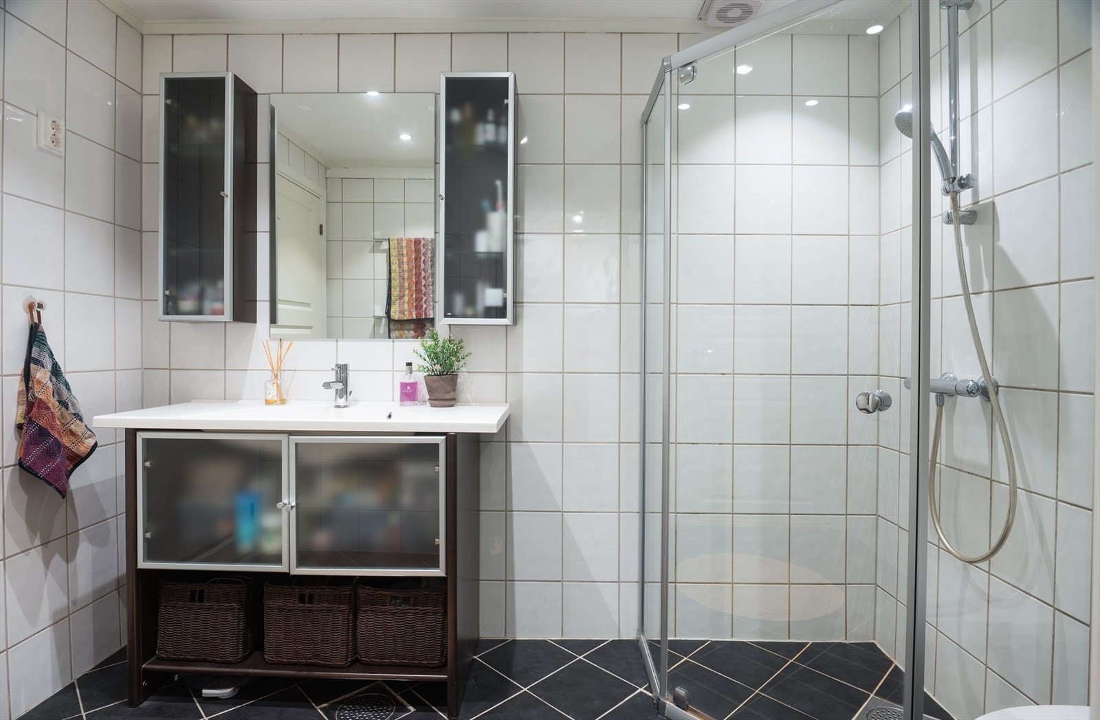 Flislagt gulv med varmekabler, flislagte vegger og malt himling med downlights. Galleribilde