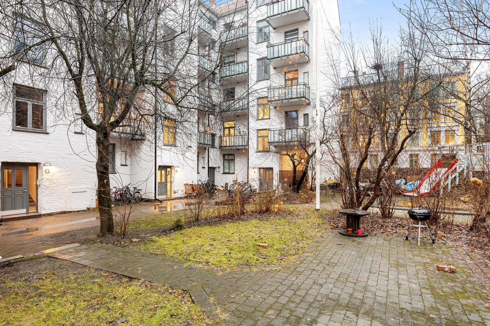 Bakgården har gressbelagte områder, lekeapparater for barn og felles grill. Galleribilde