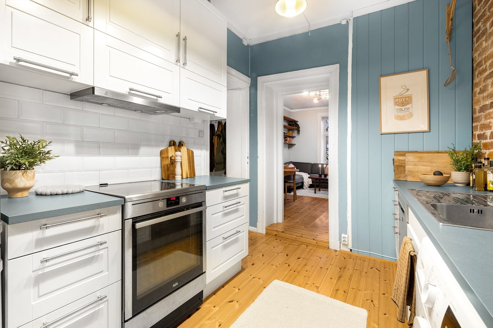 Kjøkkenet har rikelig med skapplass og plass til frittstående hvitevarer som komfyr, oppvaskmaskin, vaskemaskin og kjøle-/fryseskap. Galleribilde