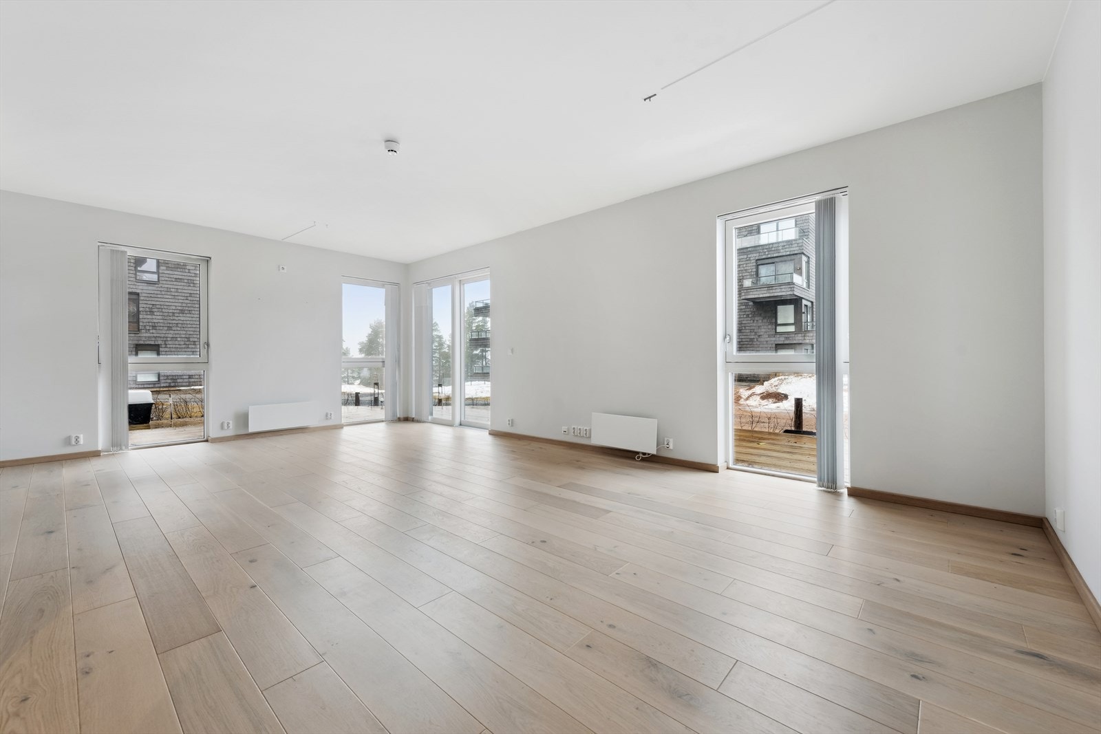 Den romslige hjørneløsningen og de mange store vinduene gir stuen en lys og luftig atmosfære Galleribilde