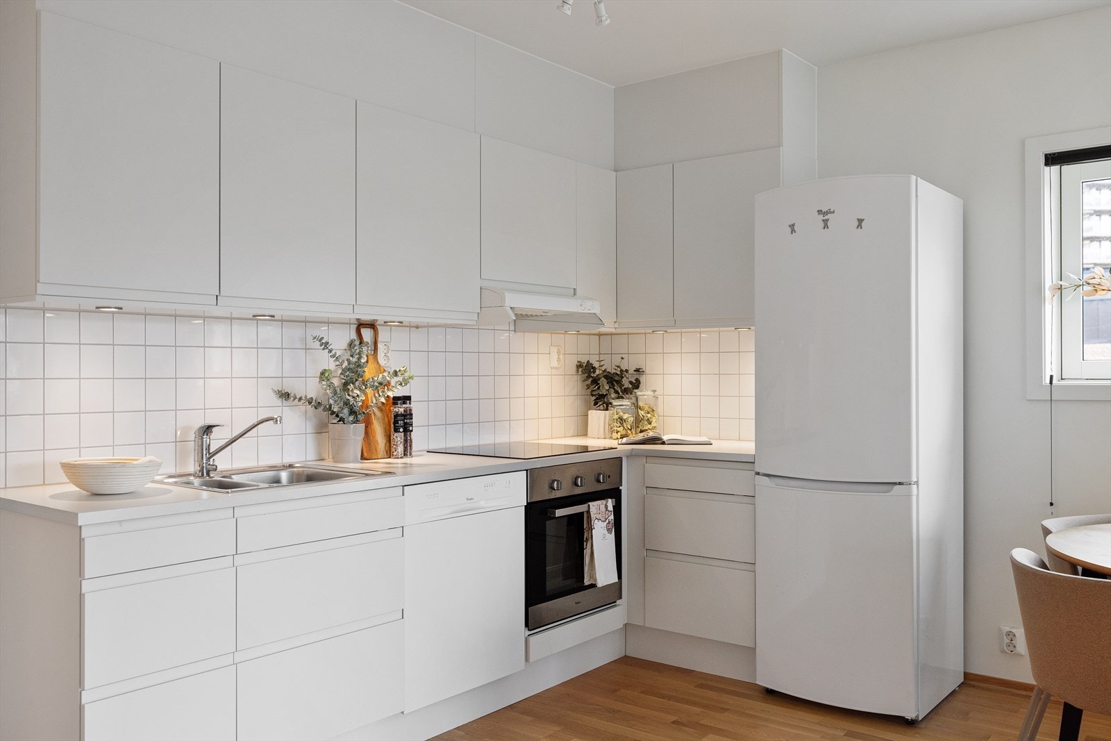 Glatte fronter, laminert benkeplate med nedfelt vaskekum samt fliser og belysning over benken gir et stilrent uttrykk. Galleribilde