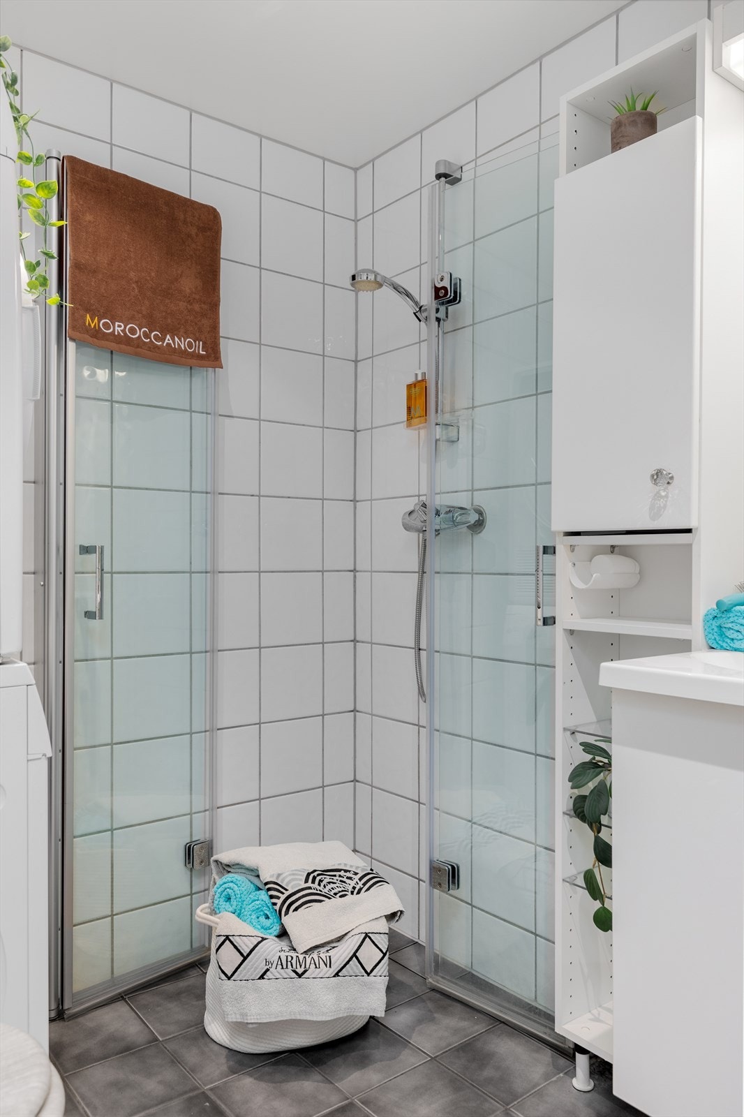 Videre er badet innredet med servantskap med speil og lys, sideskap og overskap samt toalett og dusjhjørne. Galleribilde