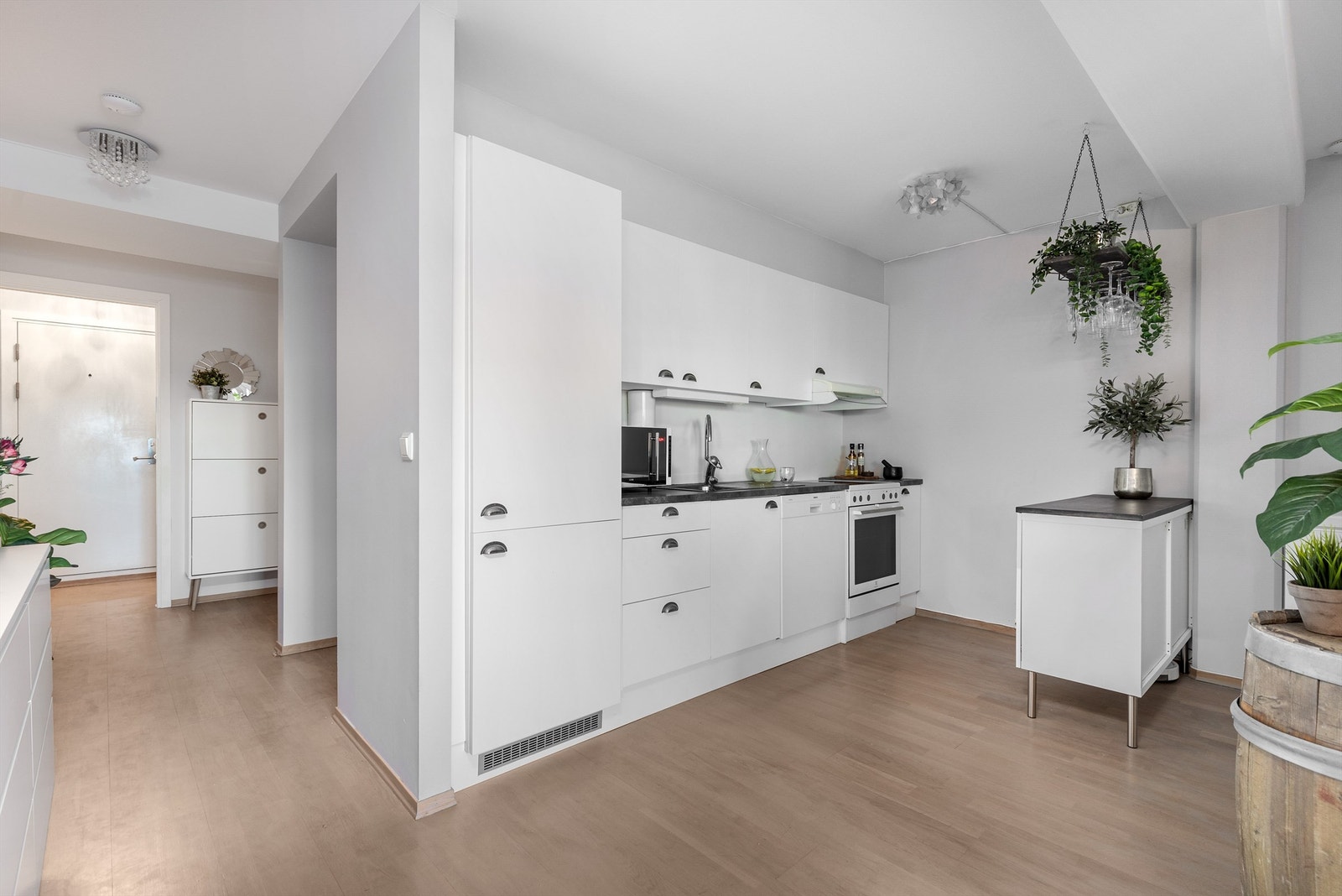 Kjøkkenet ligger naturlig tilbaketrukket fra stuen og er innredet med lyse slette flater og benkeplate i kontrast. Galleribilde