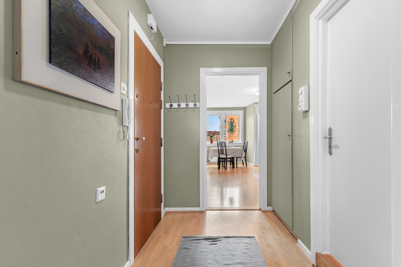 Velkommen inn! Den grønne fargetonen setter en varm og innbydende atmosfære idet du trer inn. Galleribilde