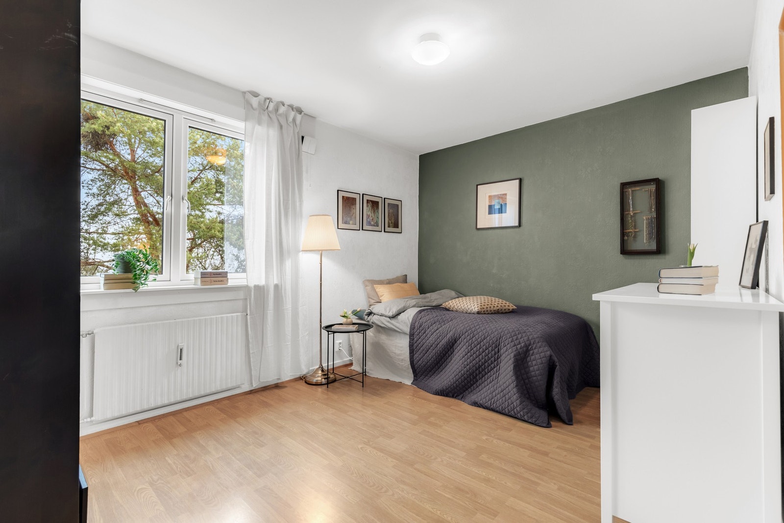 Lyse vegger skaper en luftig atmosfære, mens en grønn kontrastvegg tilfører dybde. Galleribilde