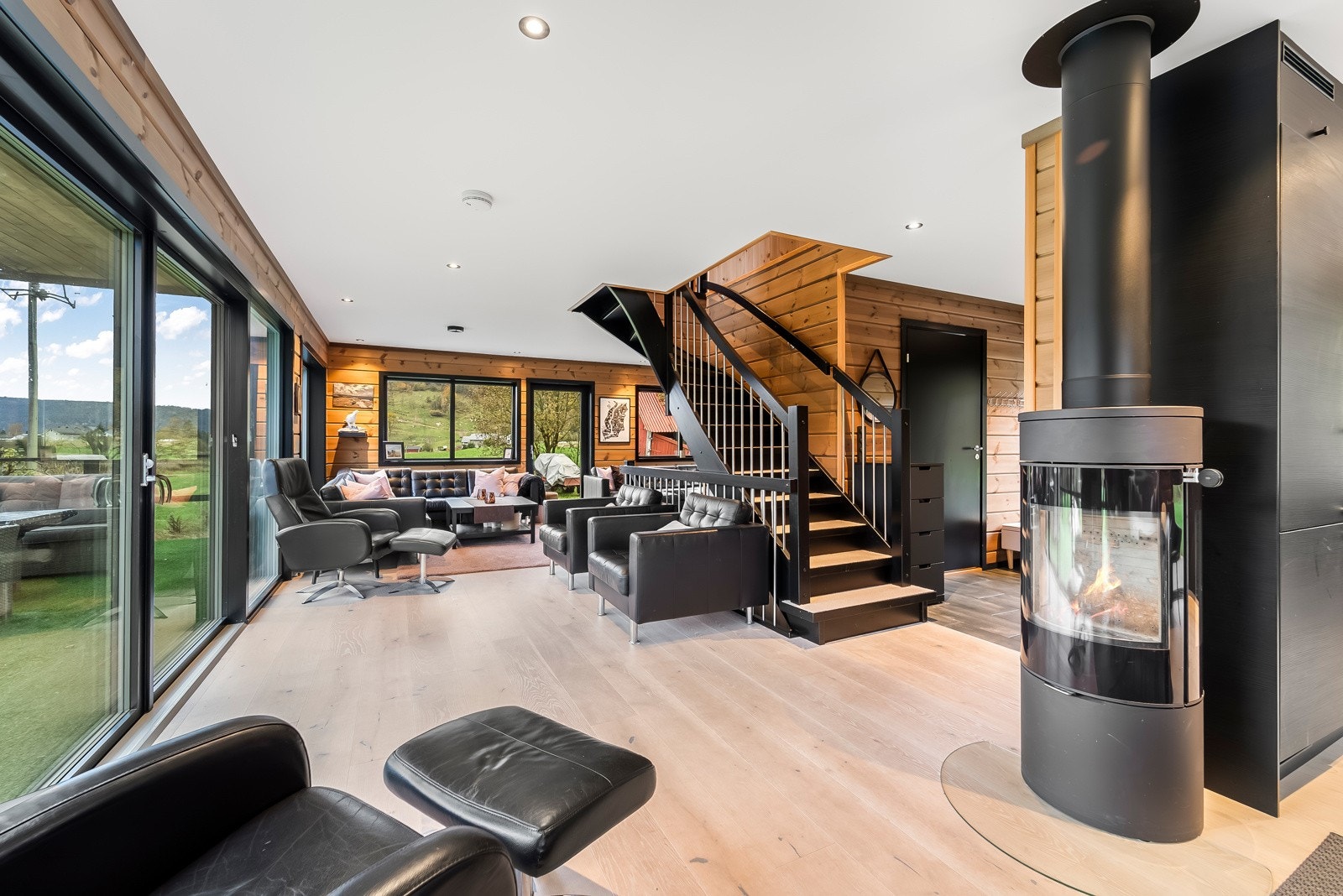 Romslig stue med vedfyring i peis. Galleribilde