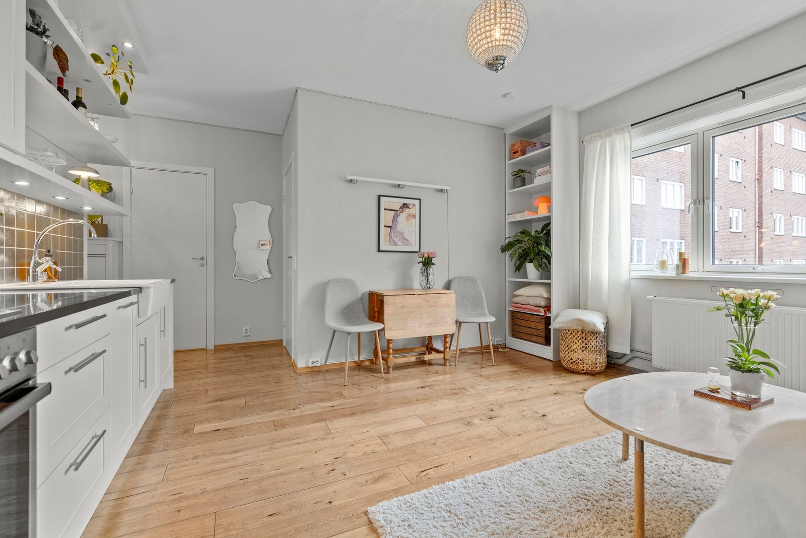 Her befinner vi oss i hjertet av boligen, nemlig stue og kjøkken. Den åpne løsningen skaper en sosial og lun atmosfære samtidig som det slippes inn rikelig med dagslys gjennom de store vindusflatene. Galleribilde