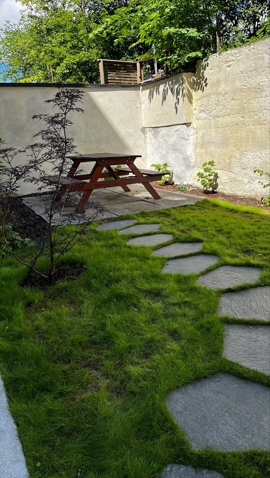 Bakgården er pent opparbeidet med heller, murt trapp sitegruppe og beplantning. Galleribilde