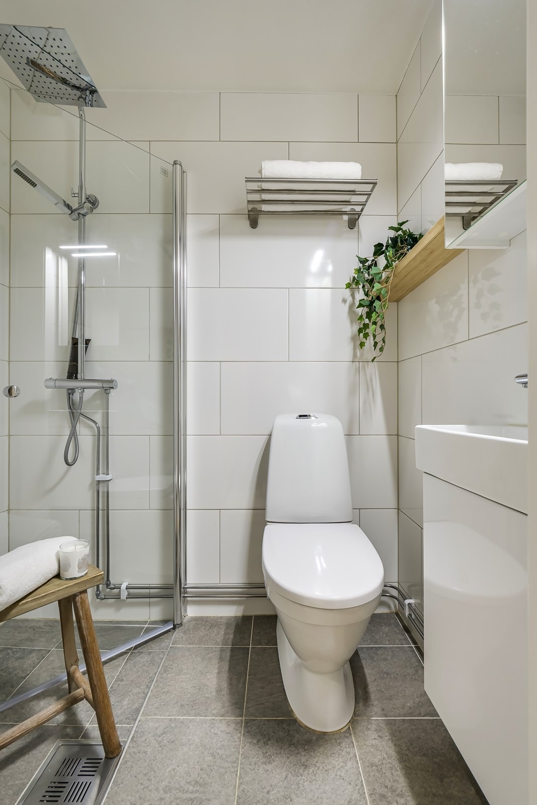 Flislagt bad med varmekabler. Badet består av servant, speil, dusjnisje og toalett. Galleribilde