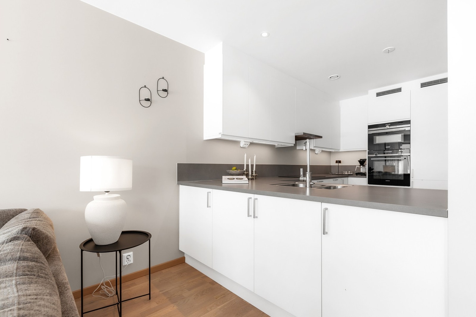 Stilren kjøkkeninnredning med slette fronter og benkeplate med vaskekum og ett-greps armatur Galleribilde