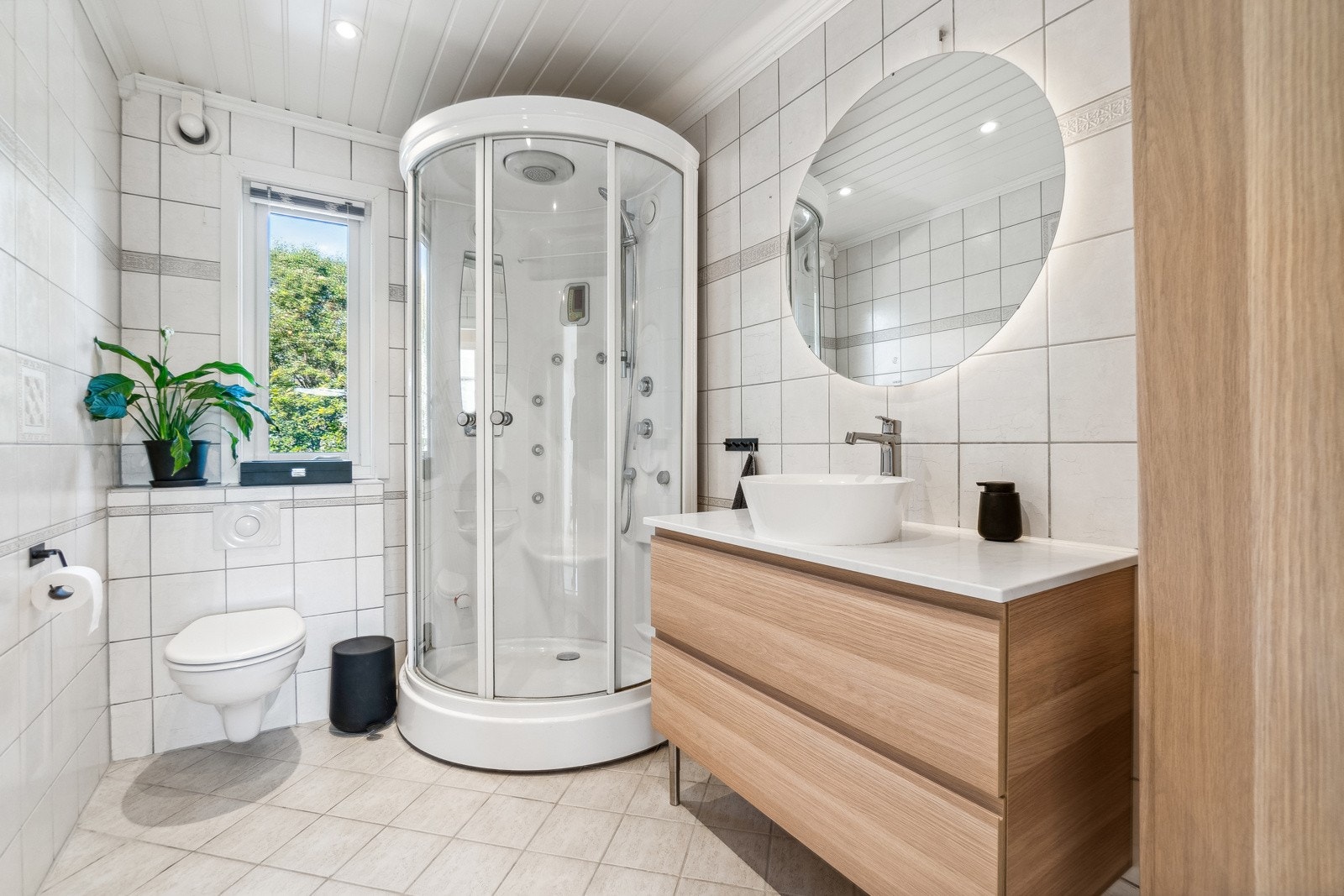 Badet i hoveddelen har en tidløs utførelse med en lys utførelse på både overflater og baderomsinnredning, og moderne løsninger som vegghengt toalett og et stilrent servantskap. Galleribilde