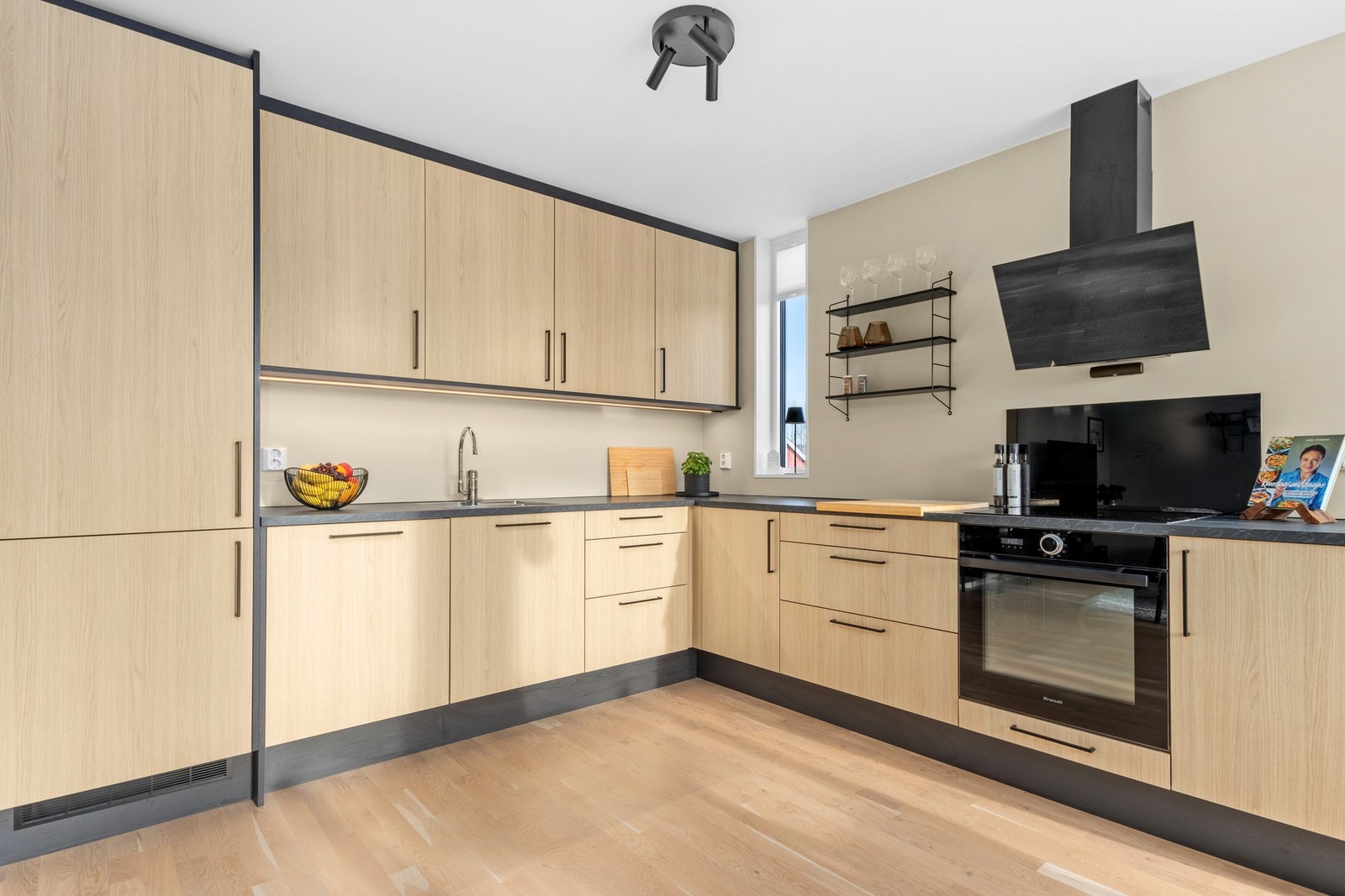 Pent kjøkken med integrerte hvitevarer. God skap- og benkeplass. Galleribilde