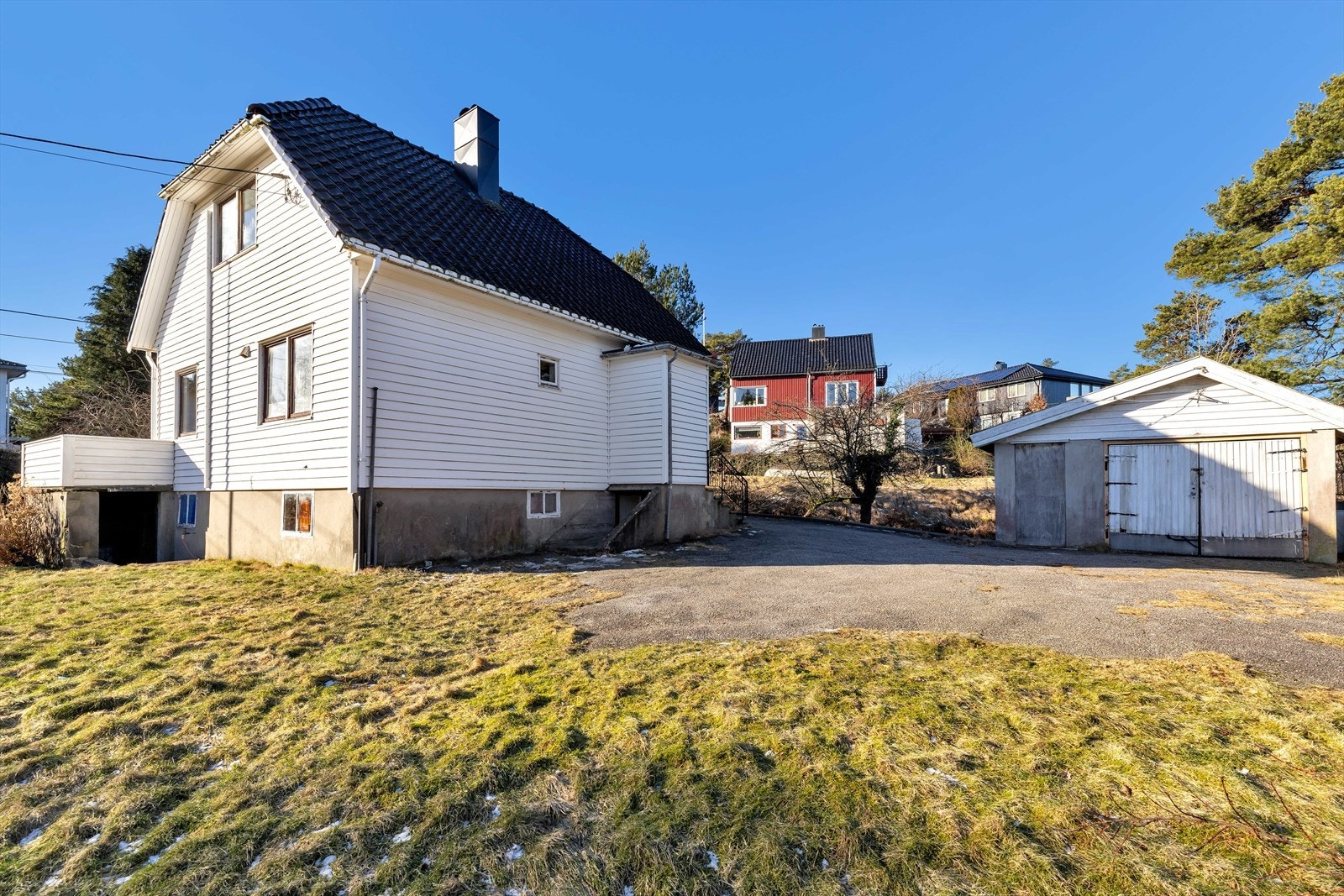 Hus, gårdsplass og garasje sett fra plenen. Galleribilde