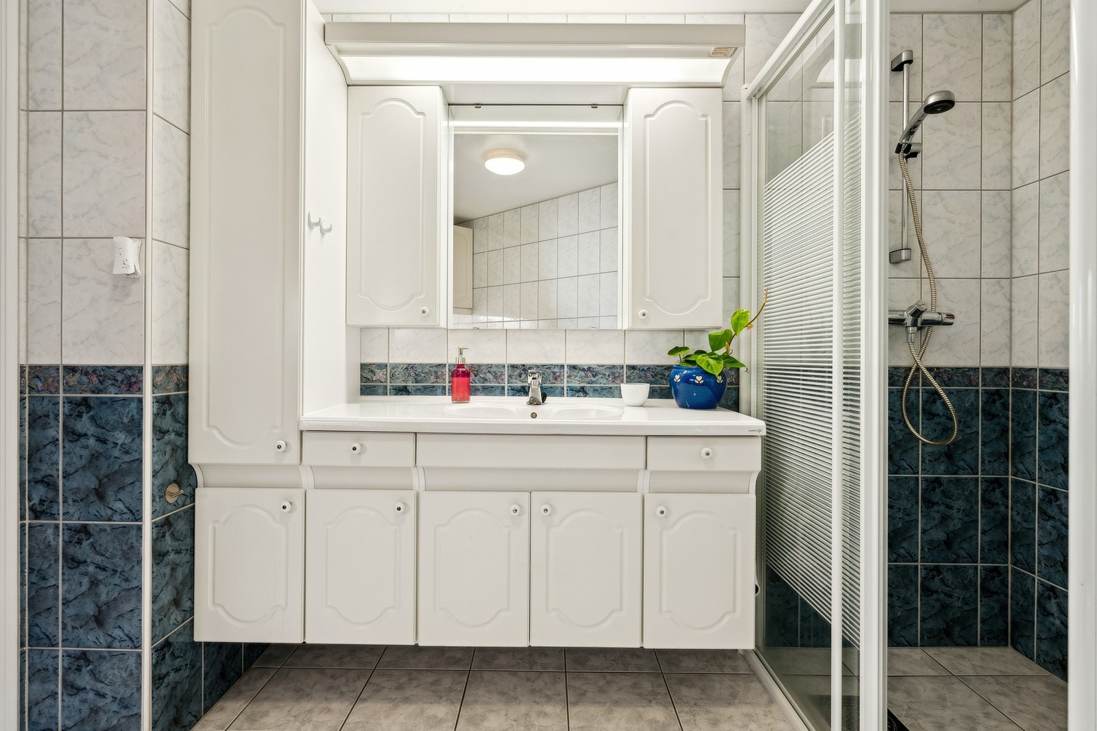 Bad med dusjhjørne, servant i innredning, wc, skyllekar og plass for vaskemaskin. Galleribilde