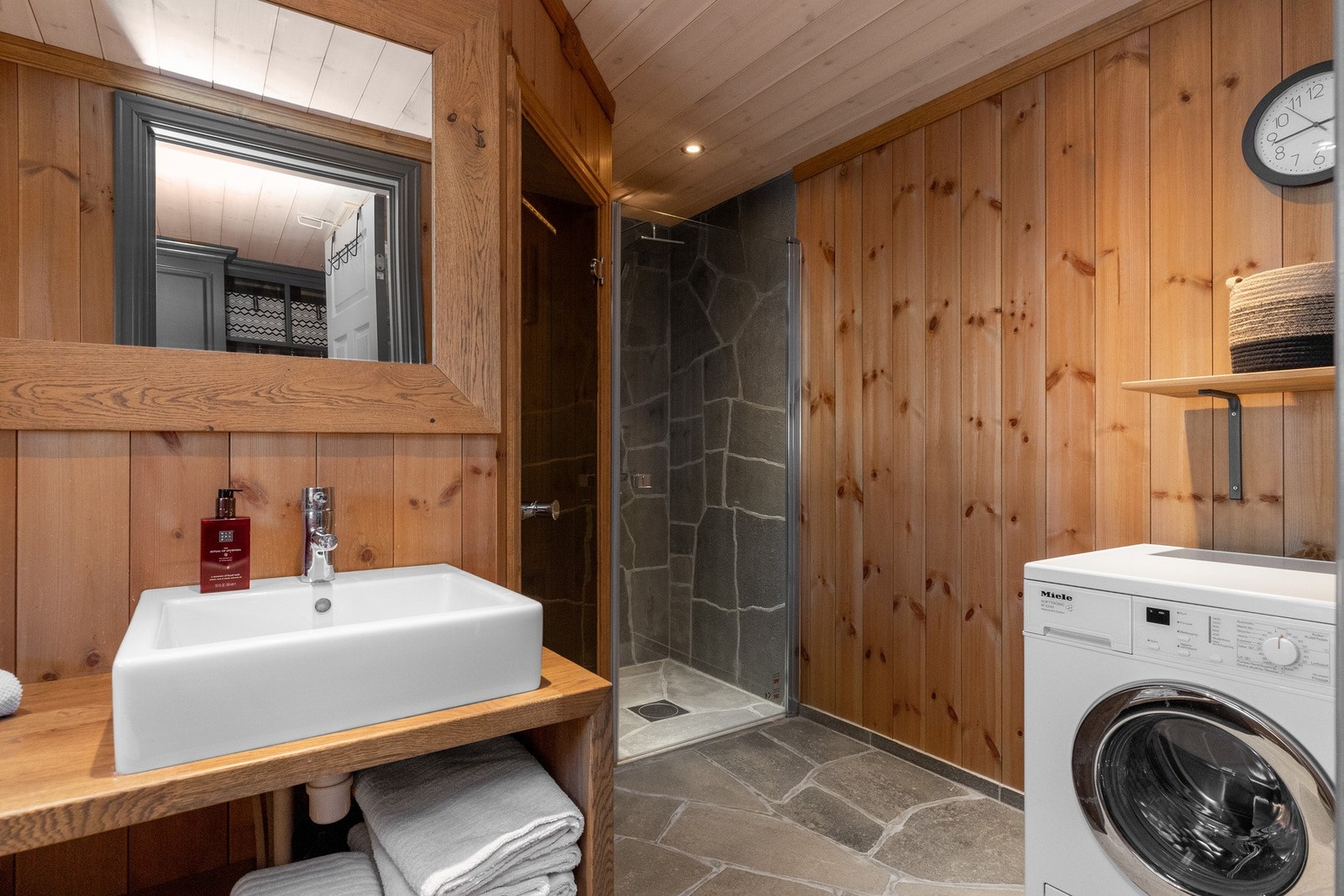 Dette badet inneholder baderomsinnredning i heltre med porselensservant, toalett, dusjhjørne og badstue. Det er også opplegg for vaskemaskin. Vaskemaskinen følger med salget Galleribilde