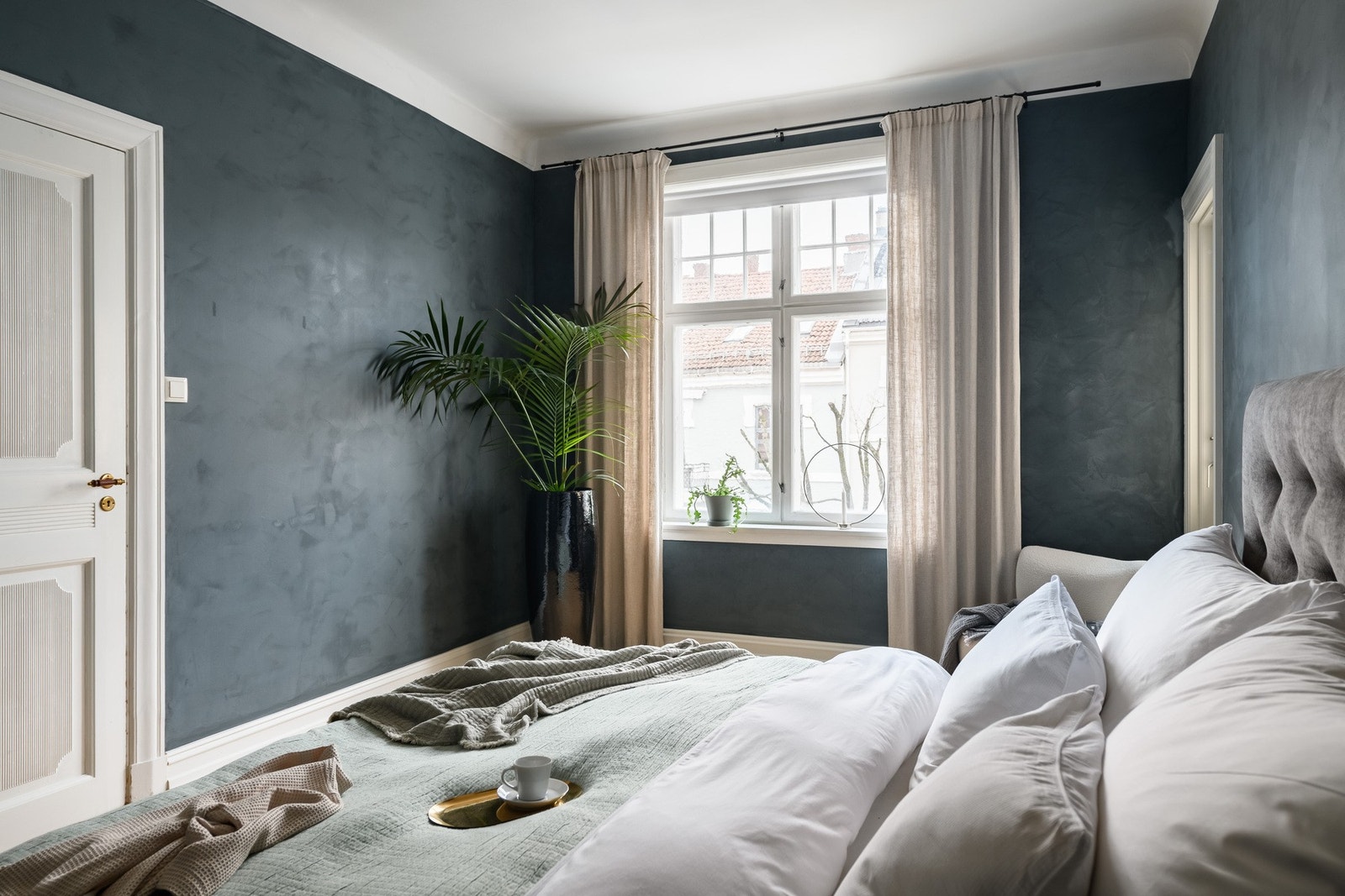 Også dette rommet har et stort vindu som fyller rommet med dagslys. Veggene er glatte malt i mørk kalkmaling Galleribilde