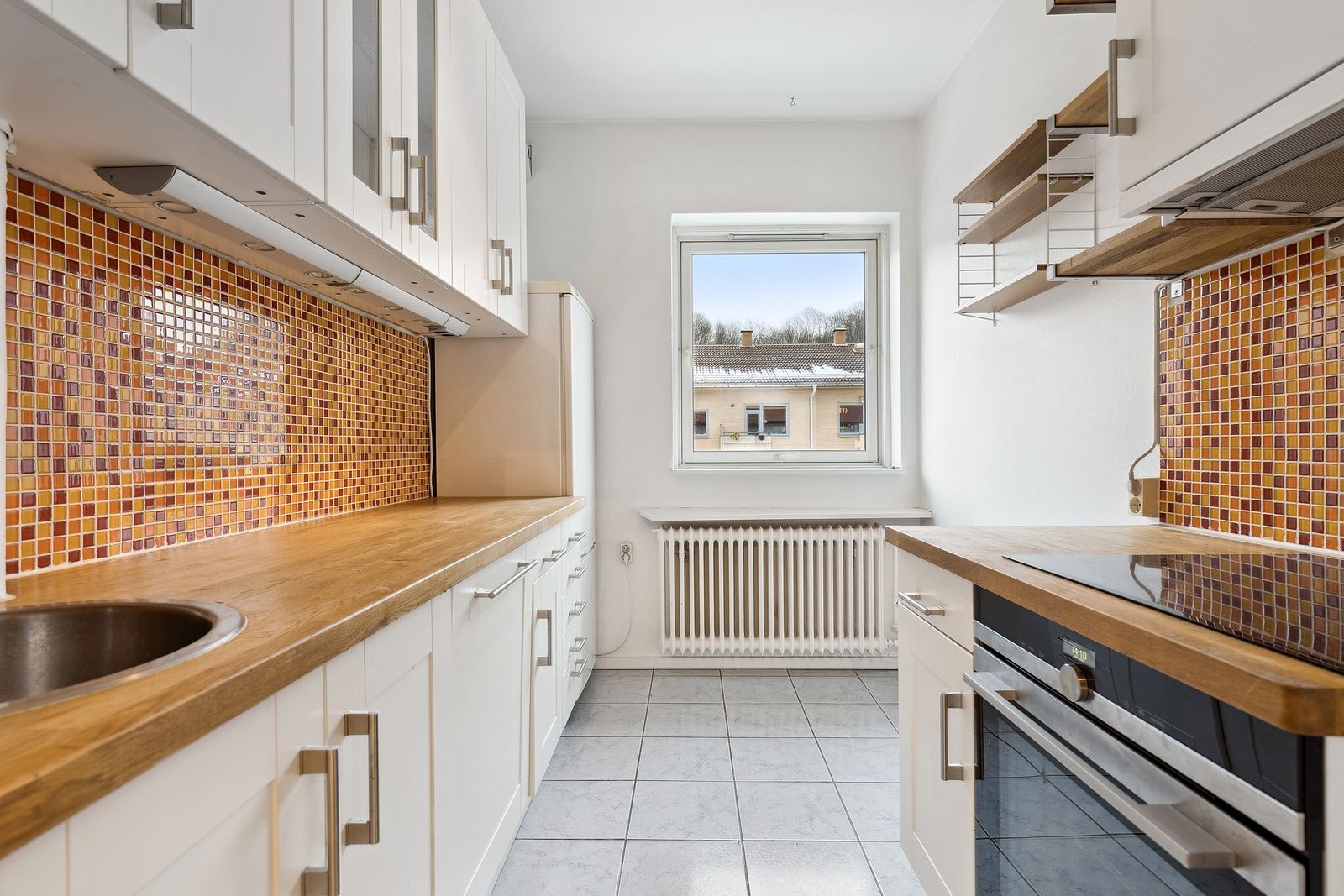 Kjøkken med integrete hvitevarer samt frittstående kjøl/frys Galleribilde