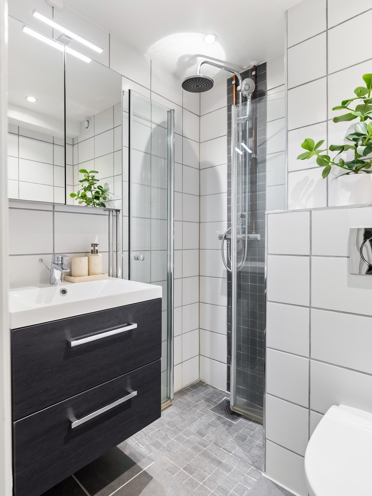 Baderommet har fliser på gulv og vegger, med downlights og malt overflate i himlingen. Selger opplyser at baderommet ble oppusset i regi av tidligere eier i 2019. Galleribilde